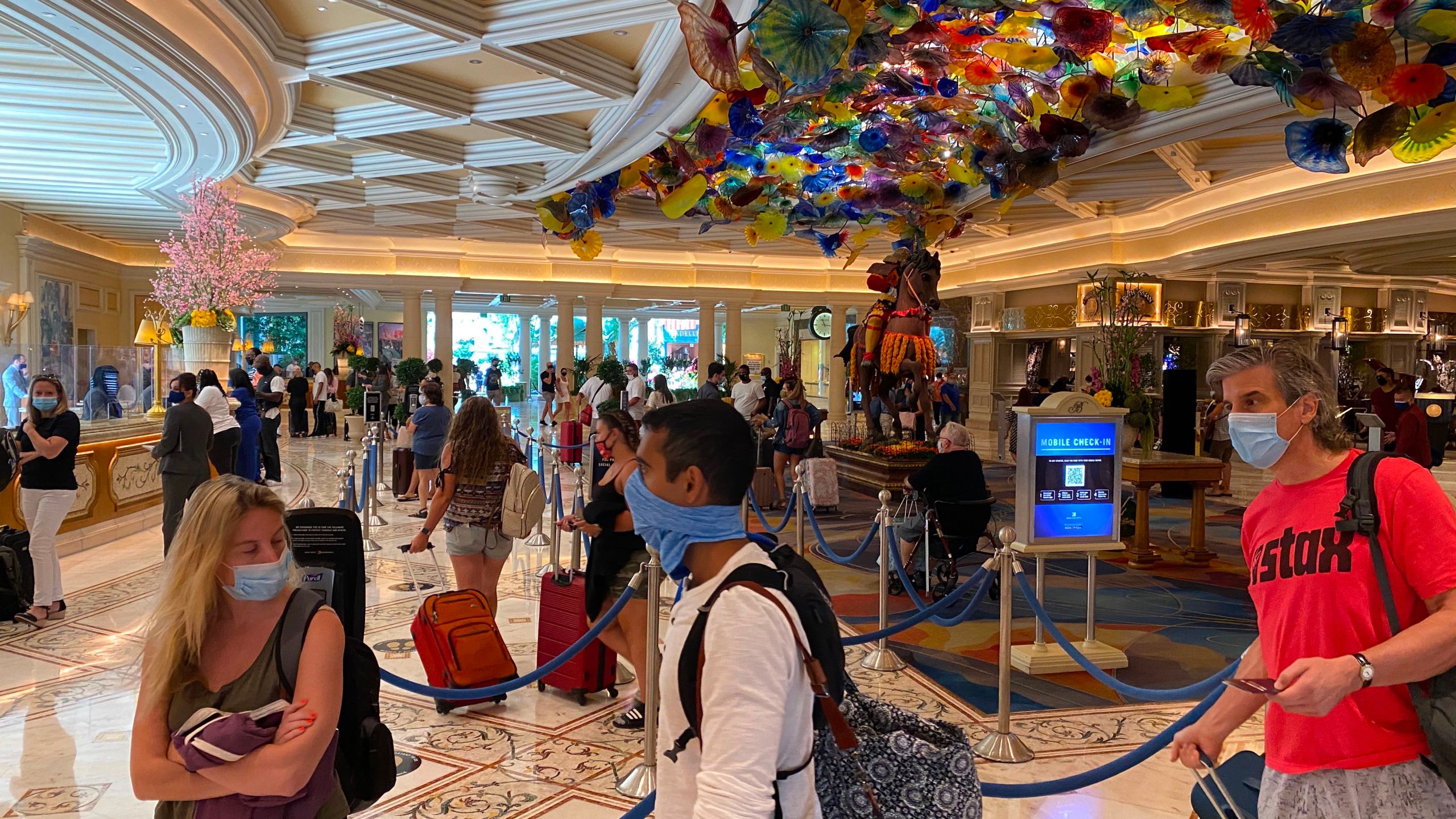 Tourists are wearing a mandatory mask as they wait to check-in at the Bellagio hotel and casino in Las Vegas, Nevada, on August 28, 2020 amid the coronavirus pandemic. (DANIEL SLIM/AFP via Getty Images)