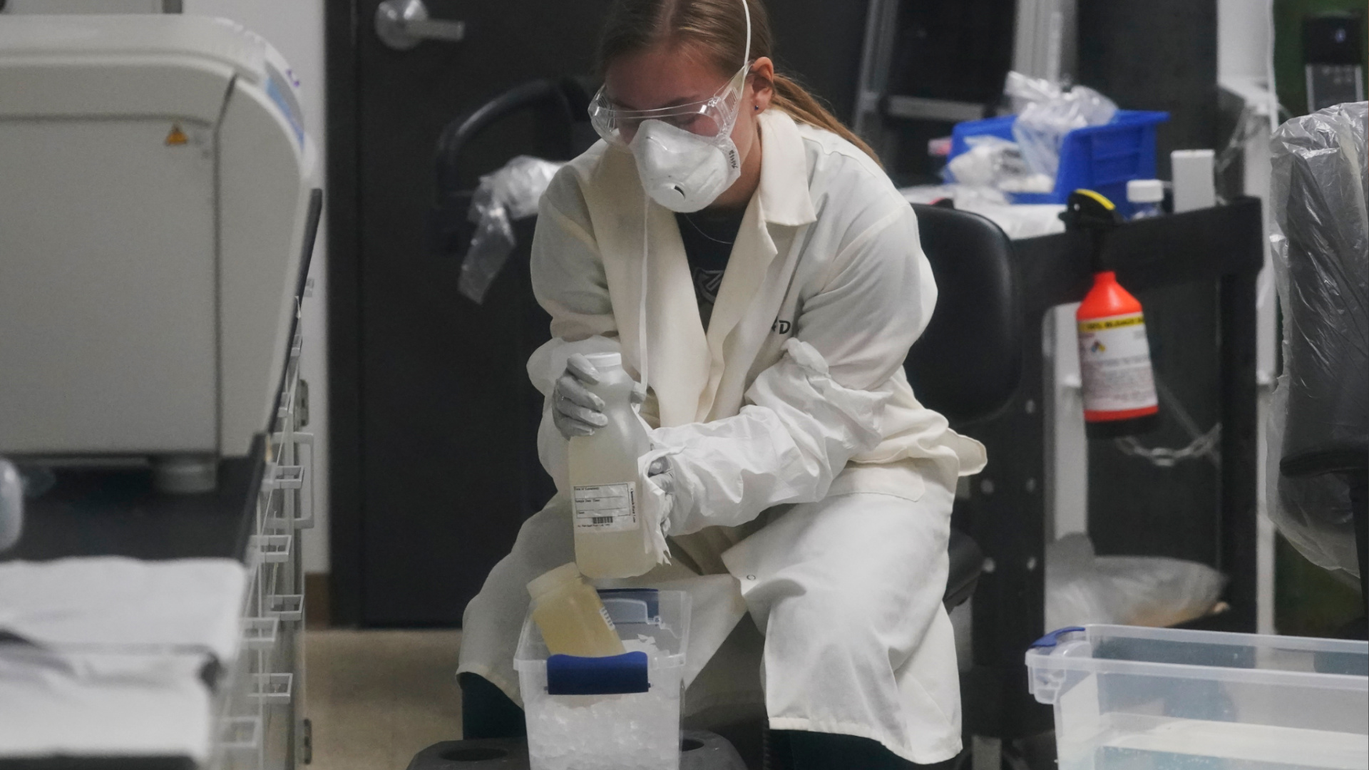 A laboratory assistant holds sewage samples collected from Utah State University dormitory's Sept. 2, 2020, in Logan, Utah. About 300 students are quarantined to their rooms this week, but not because anyone got sick or tested positive. Instead, the warning bells came from the sewage. (AP Photo/Rick Bowmer)