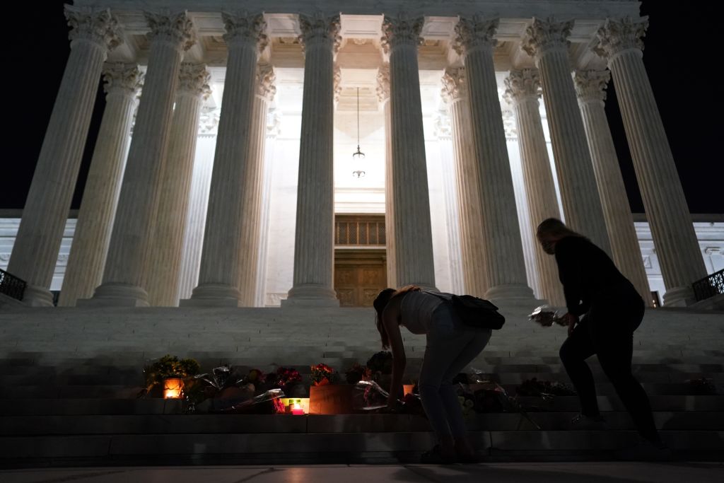 People gather at a makeshift memorial for late Justice Ruth Bader Ginsburg on the steps of the Supreme Court building on Sept. 18, 2020. (Alex Edelman / AFP / Getty Images)