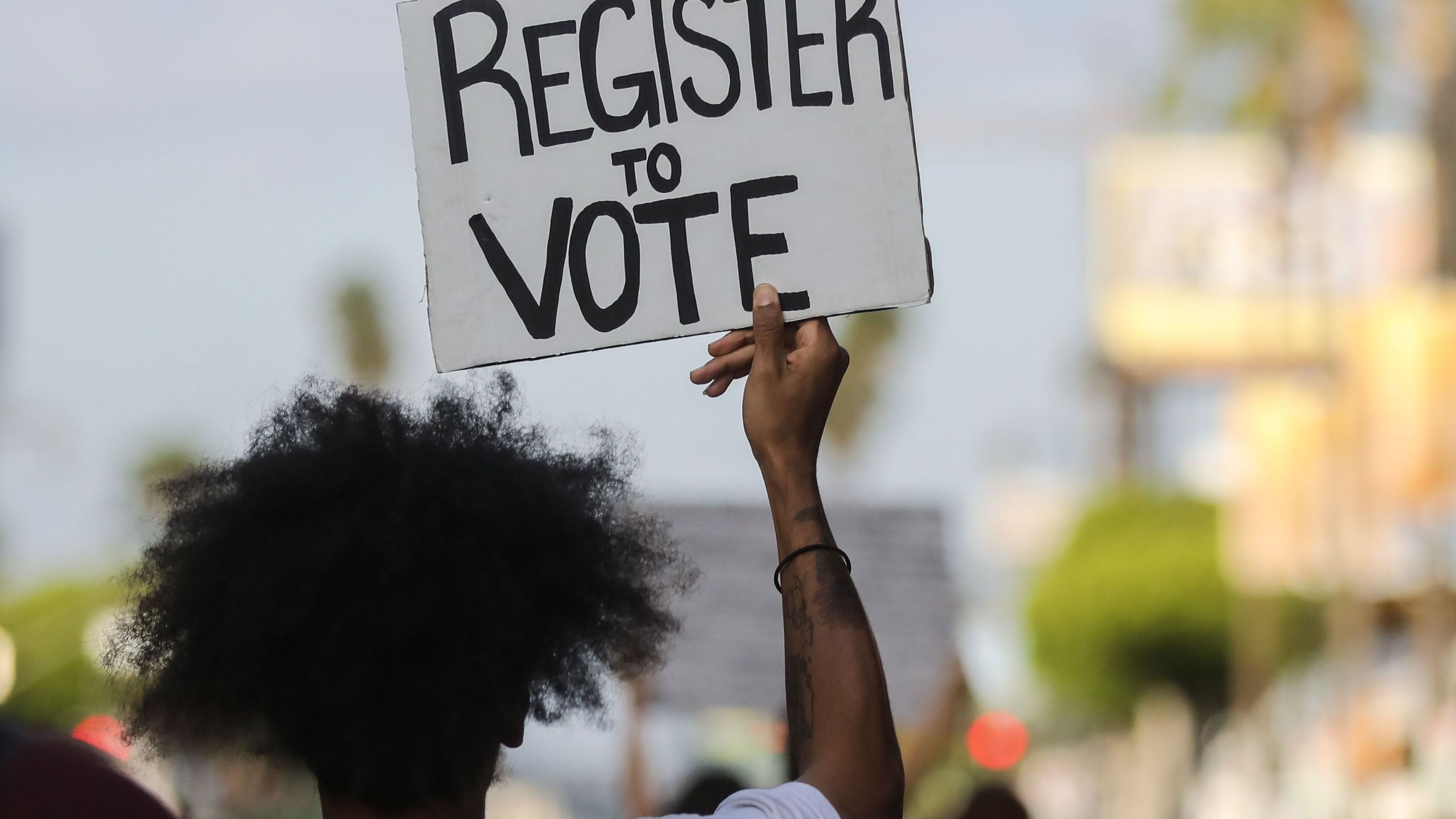 A man carries a "register to vote" sign during a demonstration on June 6, 2020 in Los Angeles. (Mario Tama/Getty Images)