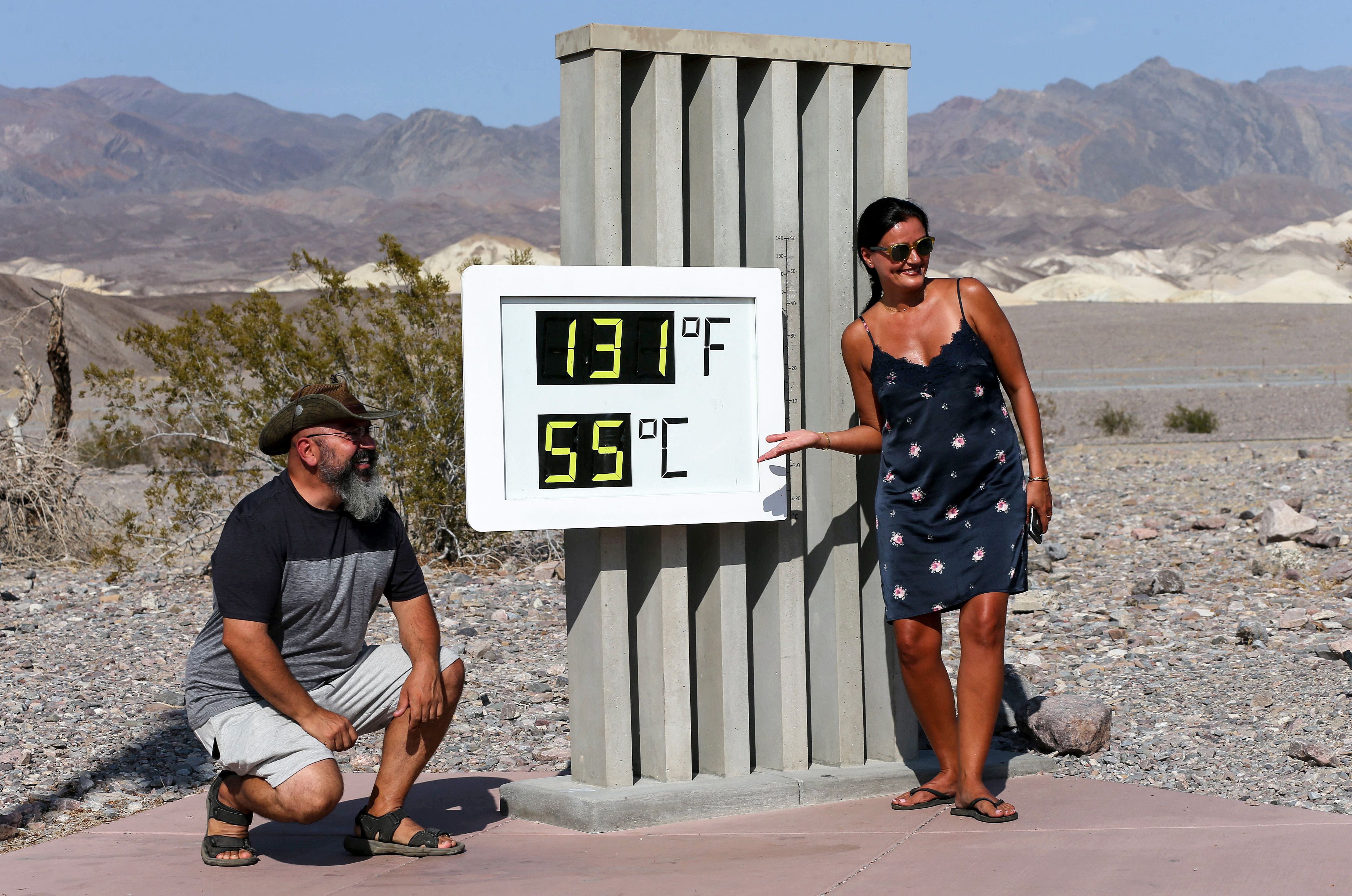 Visitors gather for a photo in front of an unofficial thermometer at Furnace Creek Visitor Center on August 17, 2020 in Death Valley National Park. (Mario Tama/Getty Images)