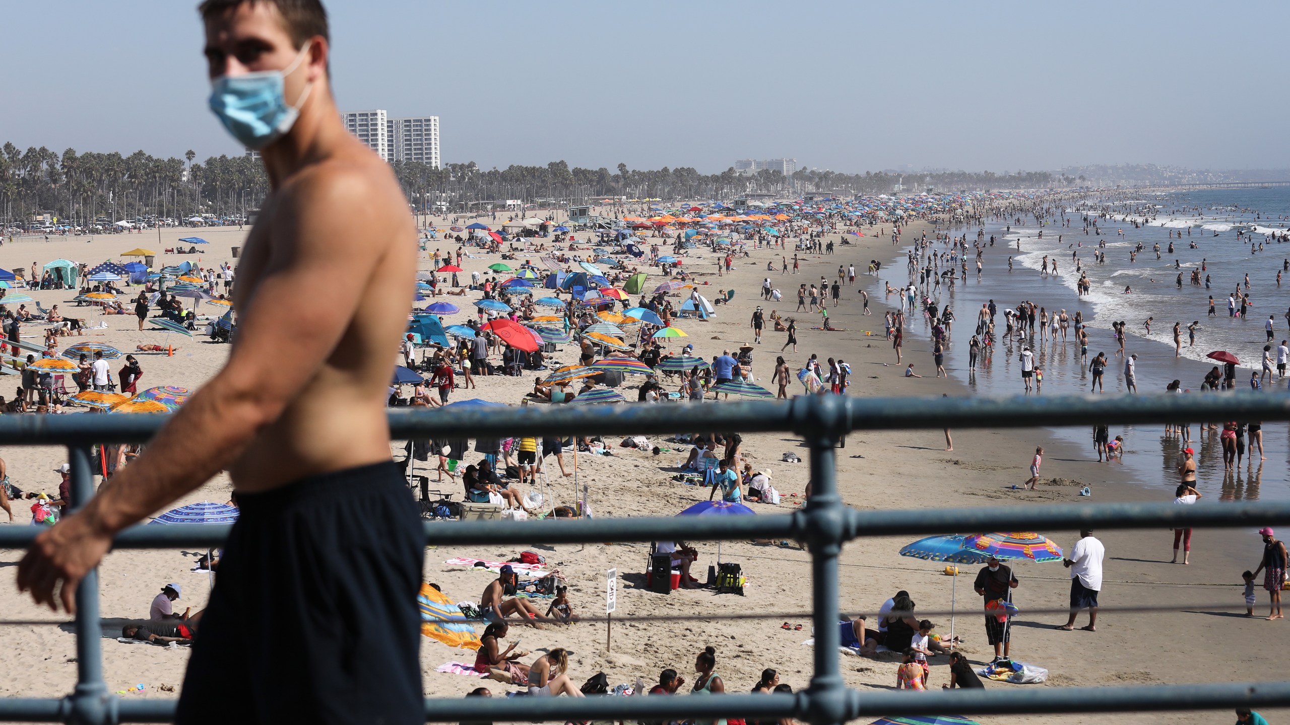 A man wears a face covering at the pier on the first day of the Labor Day weekend amid a heatwave on Sept. 5, 2020 in Santa Monica. (Photo by Mario Tama/Getty Images)