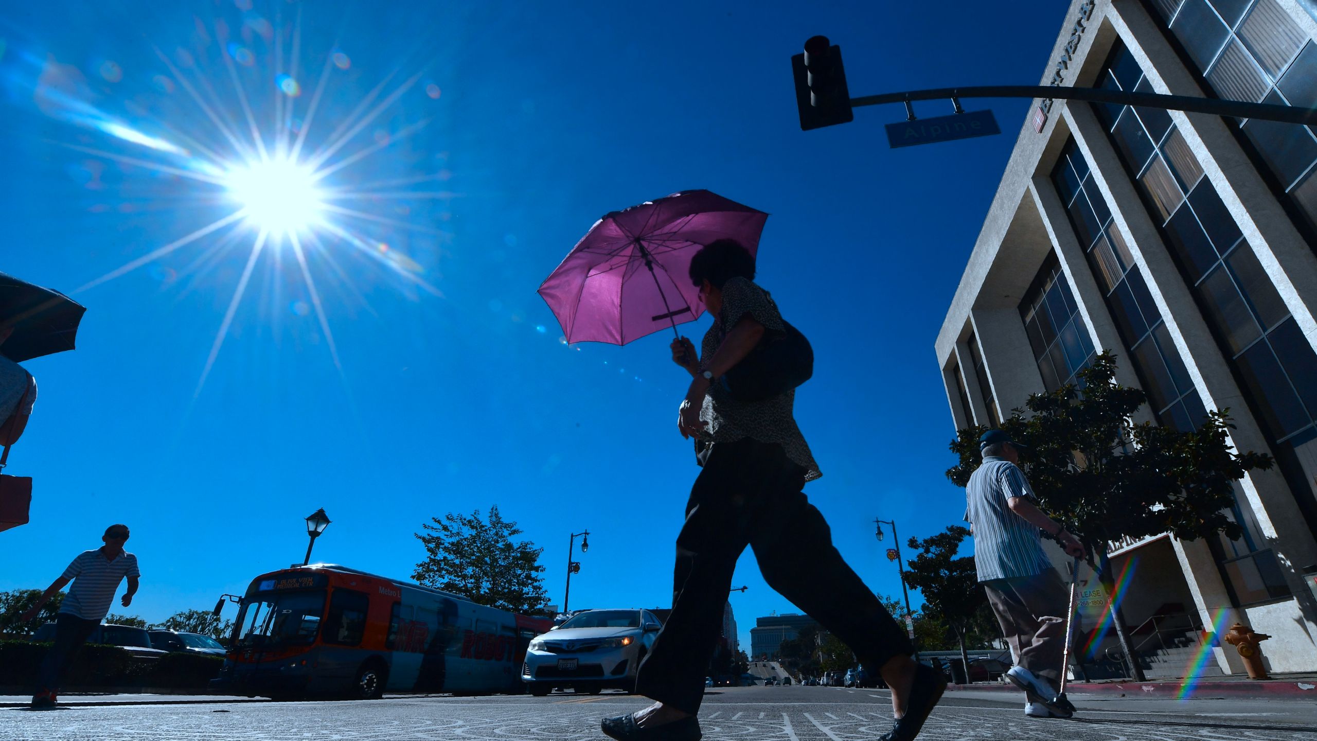 A pedestrian uses an umbrella on a hot sunny morning in Los Angeles in this file photo. (FREDERIC J. BROWN/AFP via Getty Images)