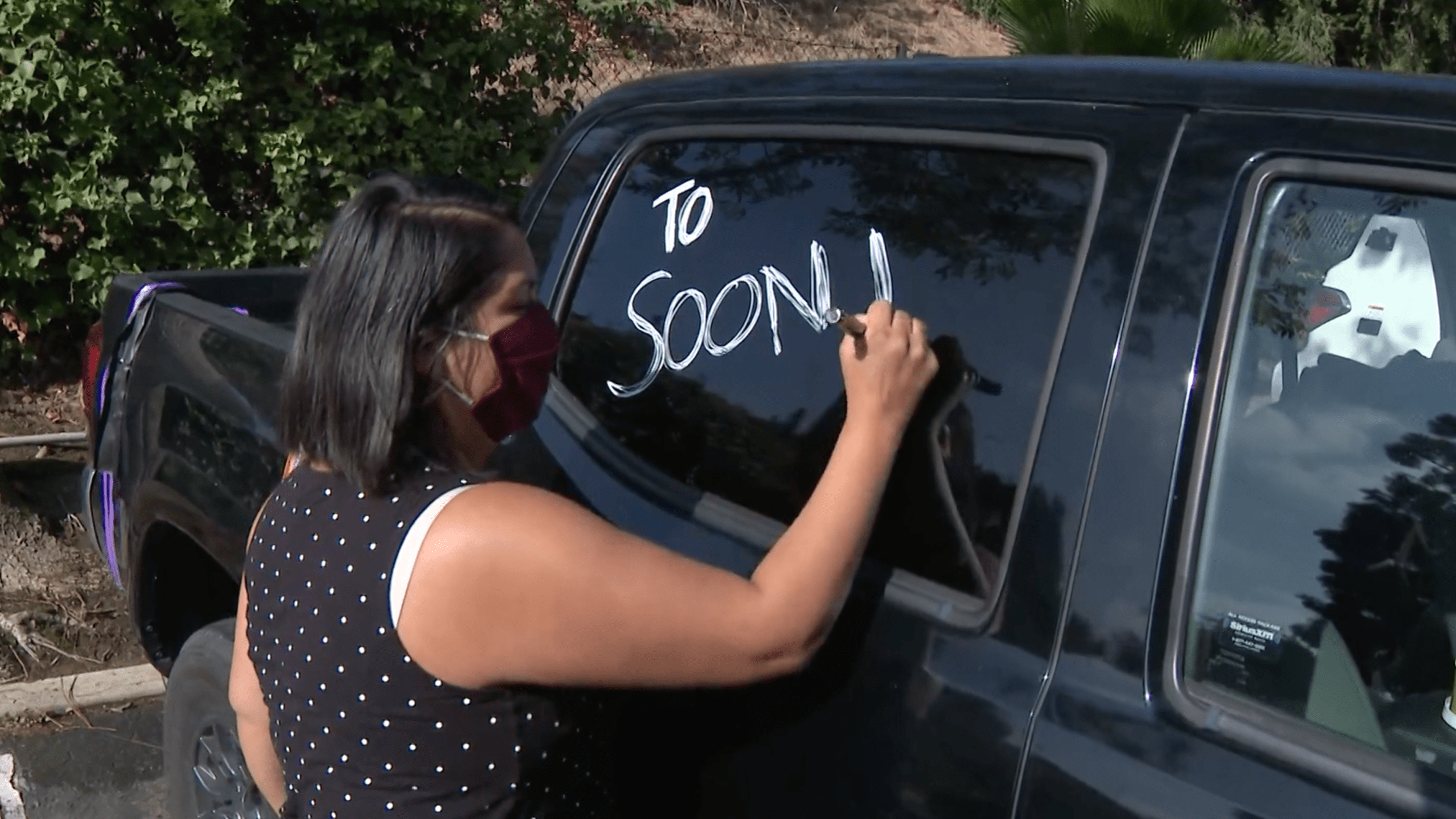 A woman prepares to participate in a caravan protesting the reopening of Newport-Mesa schools on Sept. 20, 2020, in Costa Mesa. (KTLA)