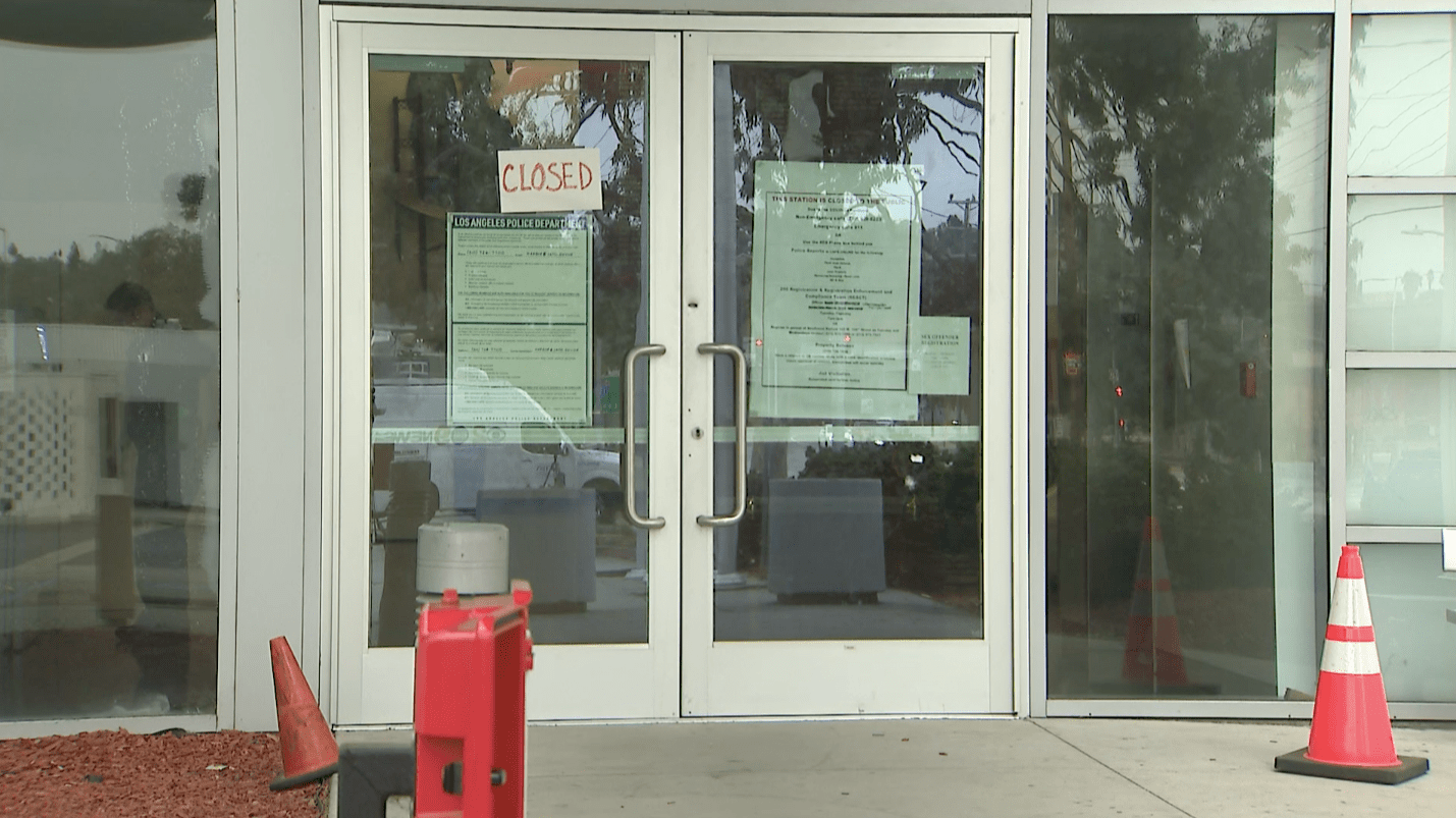 A "closed" sign is taped to the door at LAPD's Harbor Division station in San Pedro on Sept. 27, 2020. (KTLA)