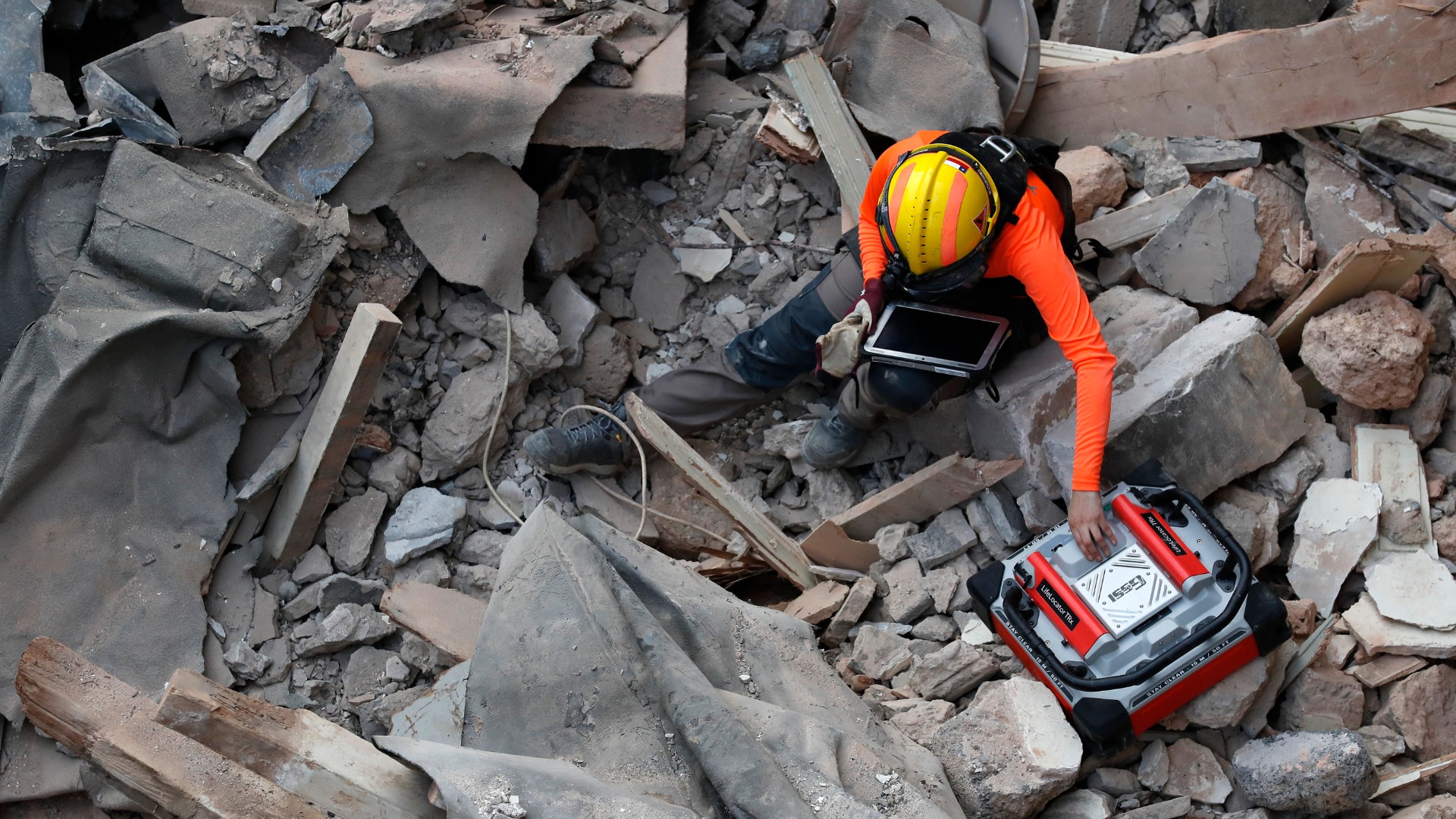 A Chilean rescuer uses a sound tracking machine at the site of a collapsed building in last month's massive explosion after getting signals there may be a survivor under the rubble in Beirut, Lebanon, Early Friday, Sept. 4, 2020. (AP Photo/Hussein Malla)