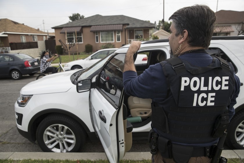 An ICE officer stands outside the home of a 47-year-old Mexican national in Montebello on April 18, 2017.(Brian van der Brug / Los Angeles Times)