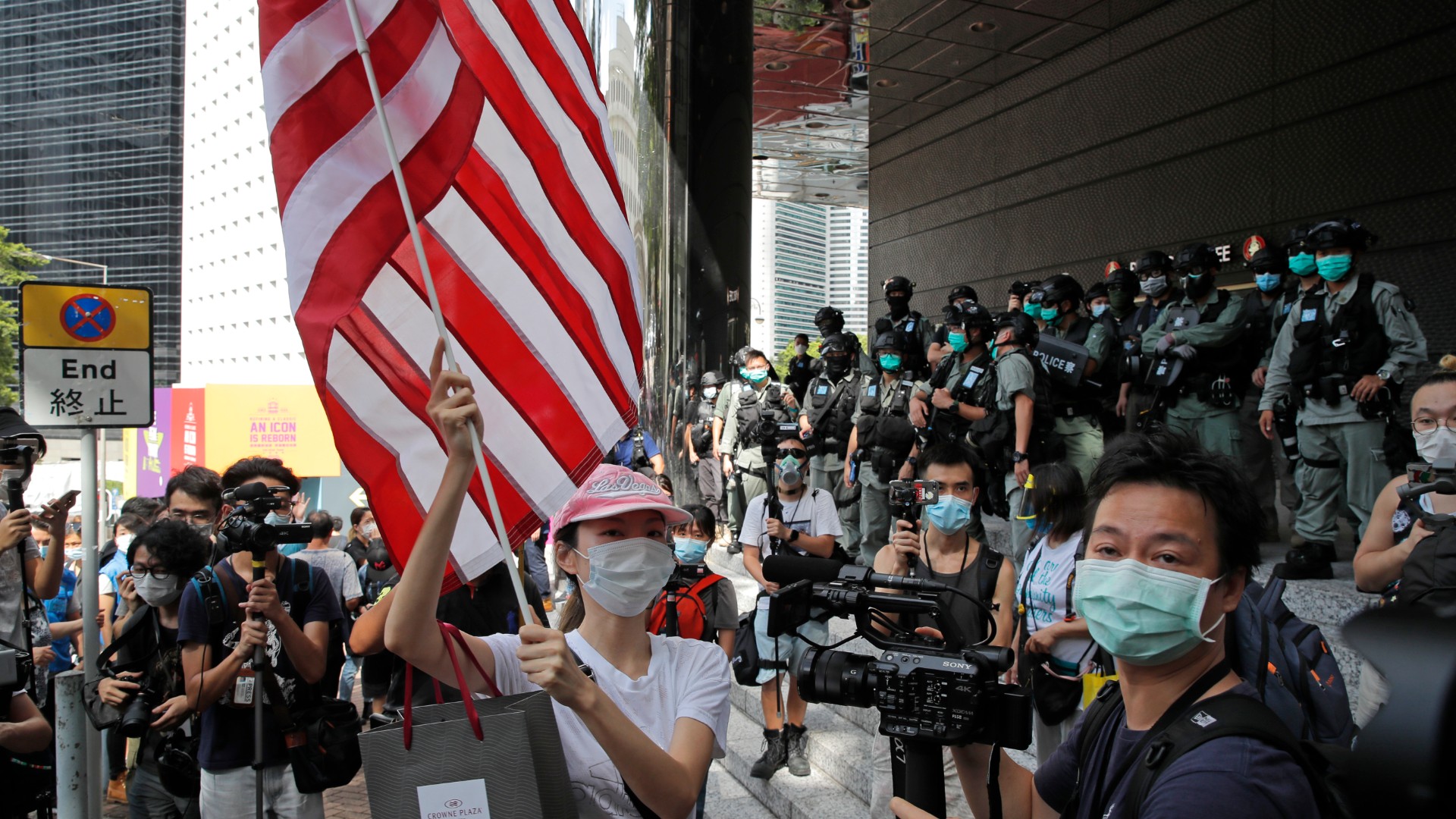 In this July 4, 2020, file photo, a woman carries an American flag during a protest outside the U.S. Consulate in Hong Kong. (AP Photo/Kin Cheung, File)