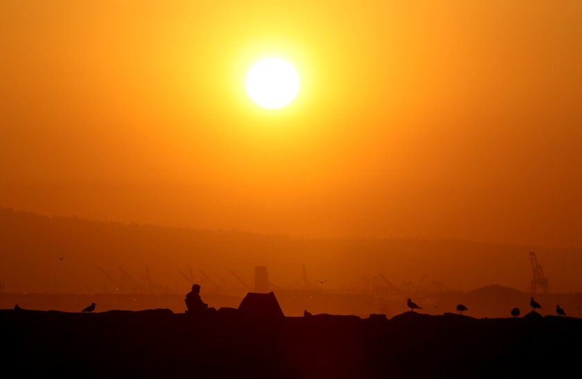 A man sits on the San Gabriel River jetty in Long Beach during Labor Day weekend in 2020. (Luis Sinco / Los Angeles Times)