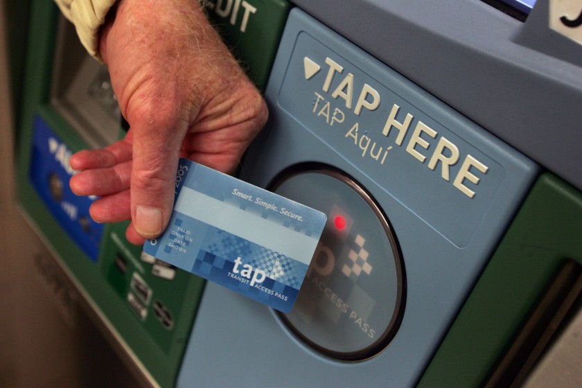 A Metro rider touches his TAP card against a ticket vending machine in downtown Los Angeles. (Los Angeles Times)