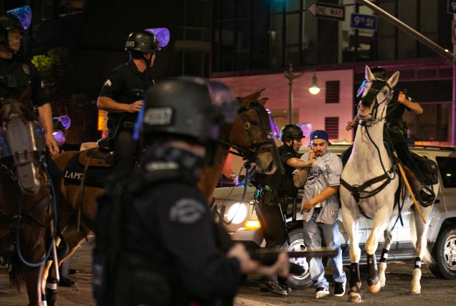 LAPD officers on horseback move in to disperse the crowds in downtown Los Angeles after the Dodgers won the World Series on Oct. 27, 2020. (Jason Armond / Los Angeles Times)