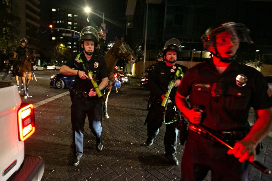 Police disperse crowds in downtown Los Angeles celebrating the Dodgers winning the World Series on Oct. 27, 2020. (Jason Armond / Los Angeles Times)