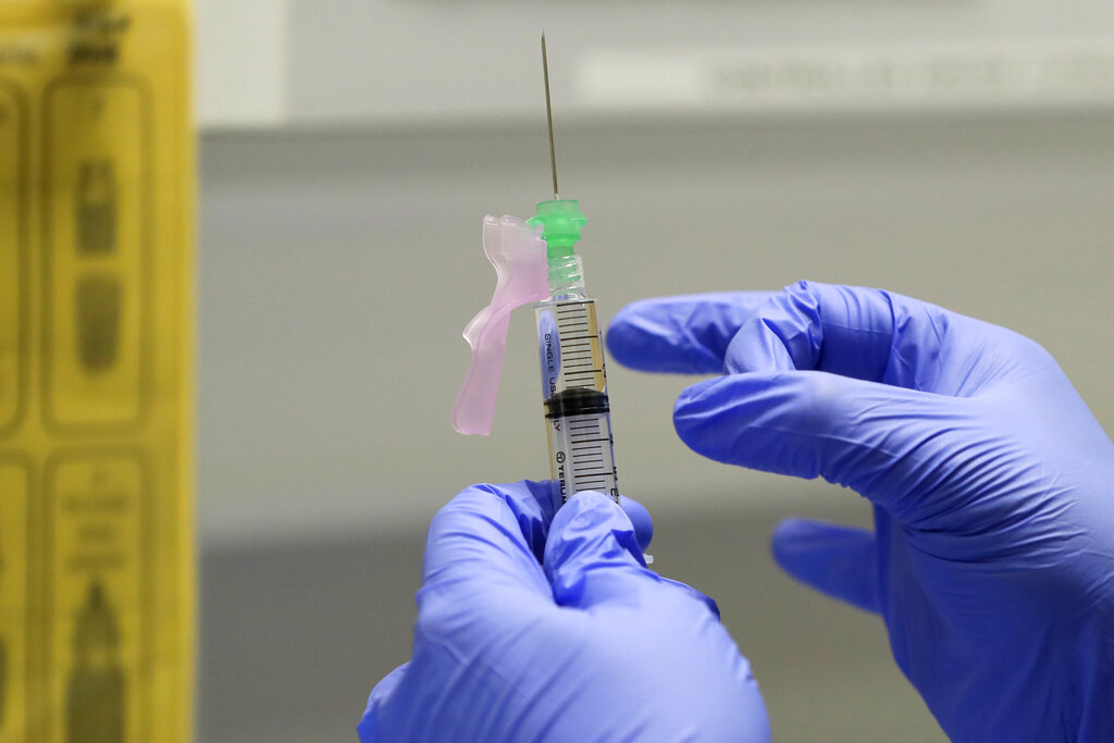 In this Aug. 5, 2020 file photo, senior Clinical Research Nurse Ajithkumar Sukumaran prepares the COVID 19 vaccine to administer to a volunteer, at a clinic in London. (AP Photo/Kirsty Wigglesworth, File)