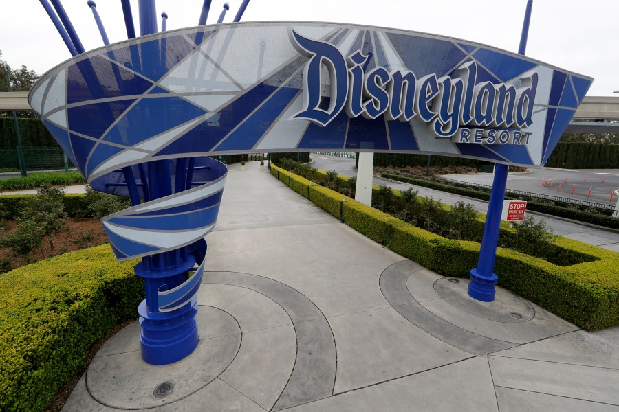 About 10,000 of the 28,000 layoffs in the company’s parks division will be hitting the Disneyland Resort parks, hotels and stores in Anaheim, according to company sources. Notifications for those layoffs are expected to reach workers via email by Sunday. This file photo from March 18, 2020 shows one of the normally bustling entrances to the Disneyland Resort. (AP Photo/Chris Carlson, File)