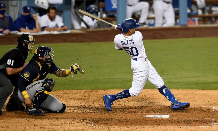 Mookie Betts #50 of the Los Angeles Dodgers two RBI double against the Milwaukee Brewers in the fifth inning of Game 2 of a National League wild-card baseball series MLB baseball game at Dodger Stadium in Los Angeles on Oct. 1, 2020. (Keith Birmingham/The Orange County Register via AP)