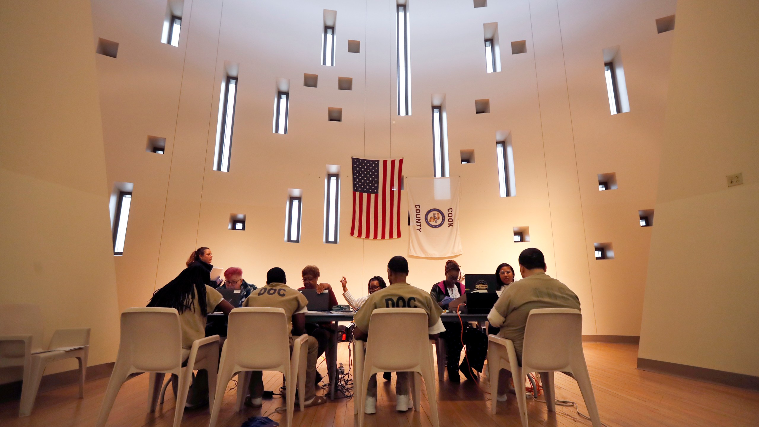 In this March 14, 2020, file photo, Chicago election officials register inmates to vote and participate in early voting for the Illinois primary at a Cook County Jail chapel. (AP Photo/Charles Rex Arbogast, File)