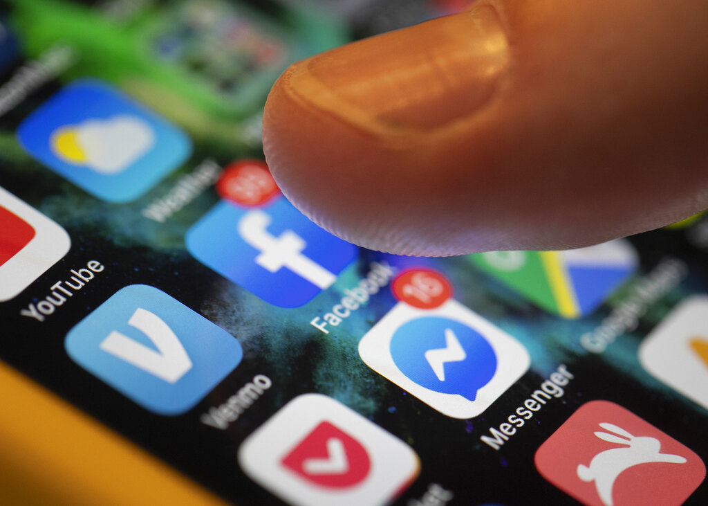 An iPhone displays the apps for Facebook and Messenger in New Orleans on Aug. 11, 2019. (Jenny Kane / Associated Press)