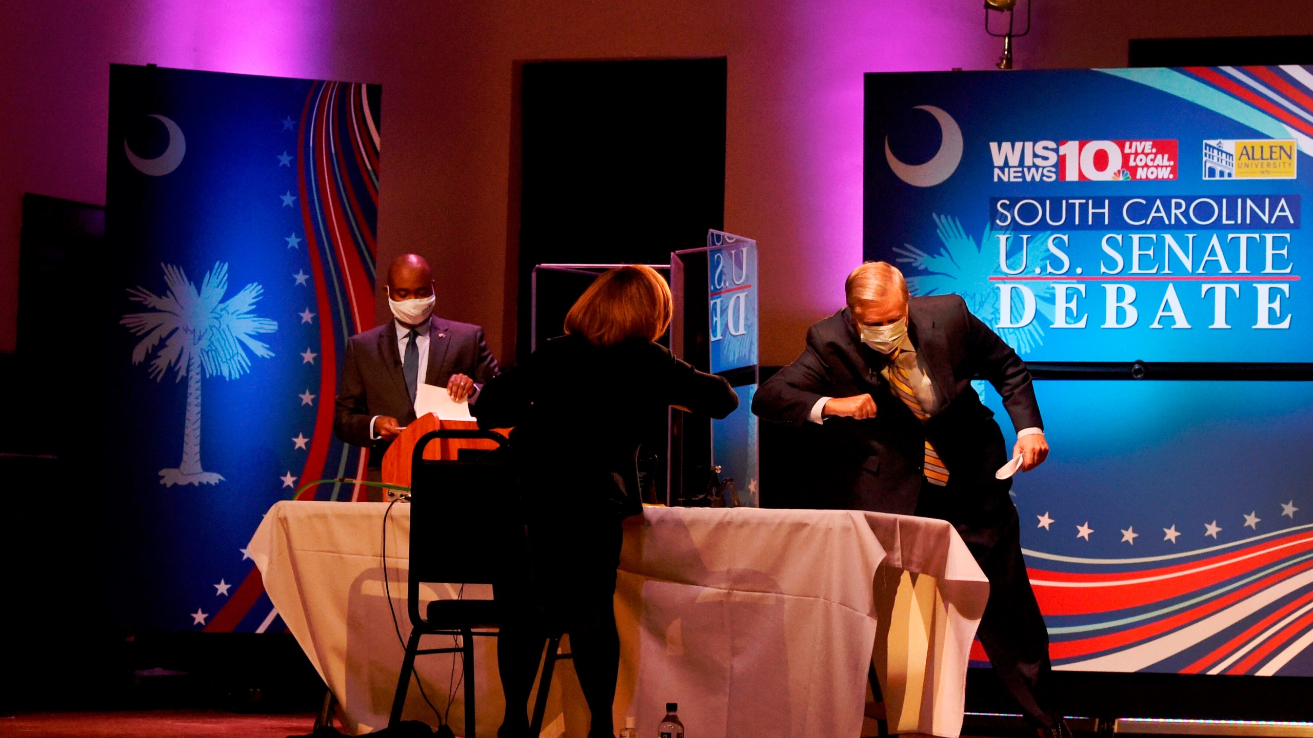 U.S. Sen. Lindsey Graham, right, R-S.C., and moderator Judi Gatson, elbow bump after the first debate between Graham and Democratic challenger Jaime Harrison, left, on Saturday, Oct. 3, 2020, in Columbia, S.C. (AP Photo/Meg Kinnard)