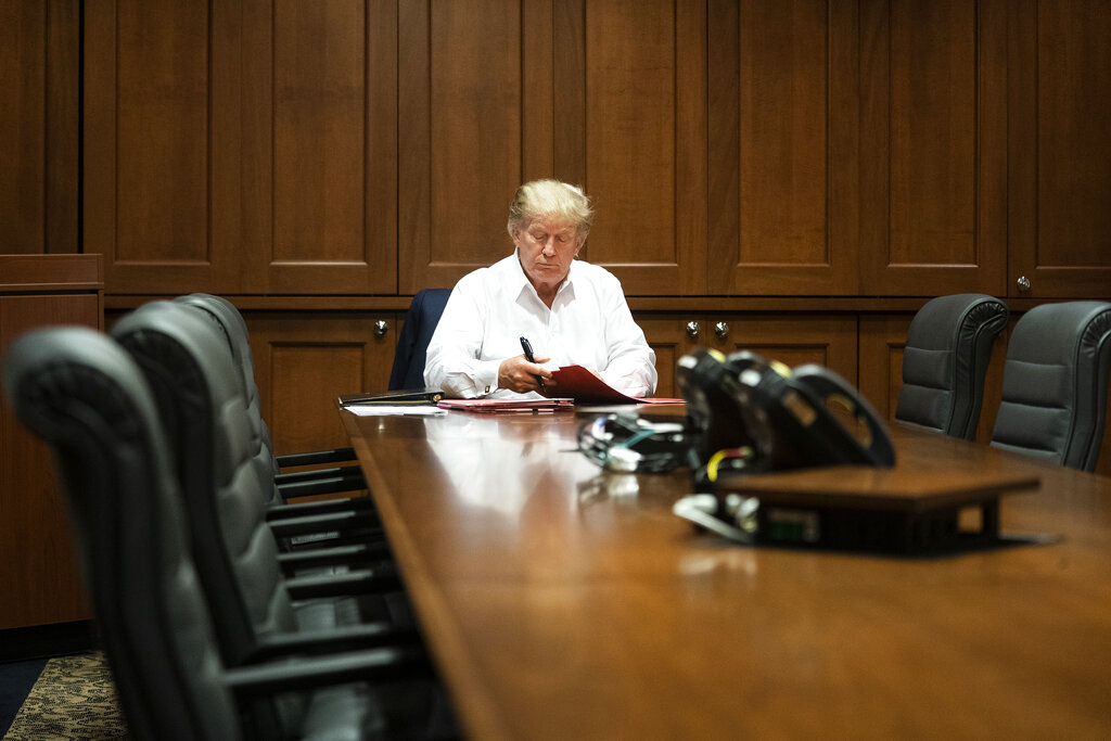 In this image released by the White House, President Donald Trump works in his conference room at Walter Reed National Military Medical Center in Bethesda, Md., Saturday, Oct. 3, 2020, after testing positive for COVID-19. (Joyce N. Boghosian/The White House via AP)