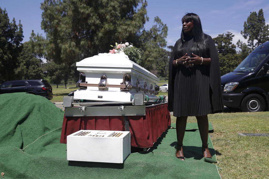 In this July 21, 2020, file photo, Candy Boyd, owner of Boyd Funeral Home, speaks to family members at an interment for Lydia Nunez, who died from COVID-19, at the Rose Hills Cemetery in Whittier, Calif. (AP Photo/Marcio Jose Sanchez, File)