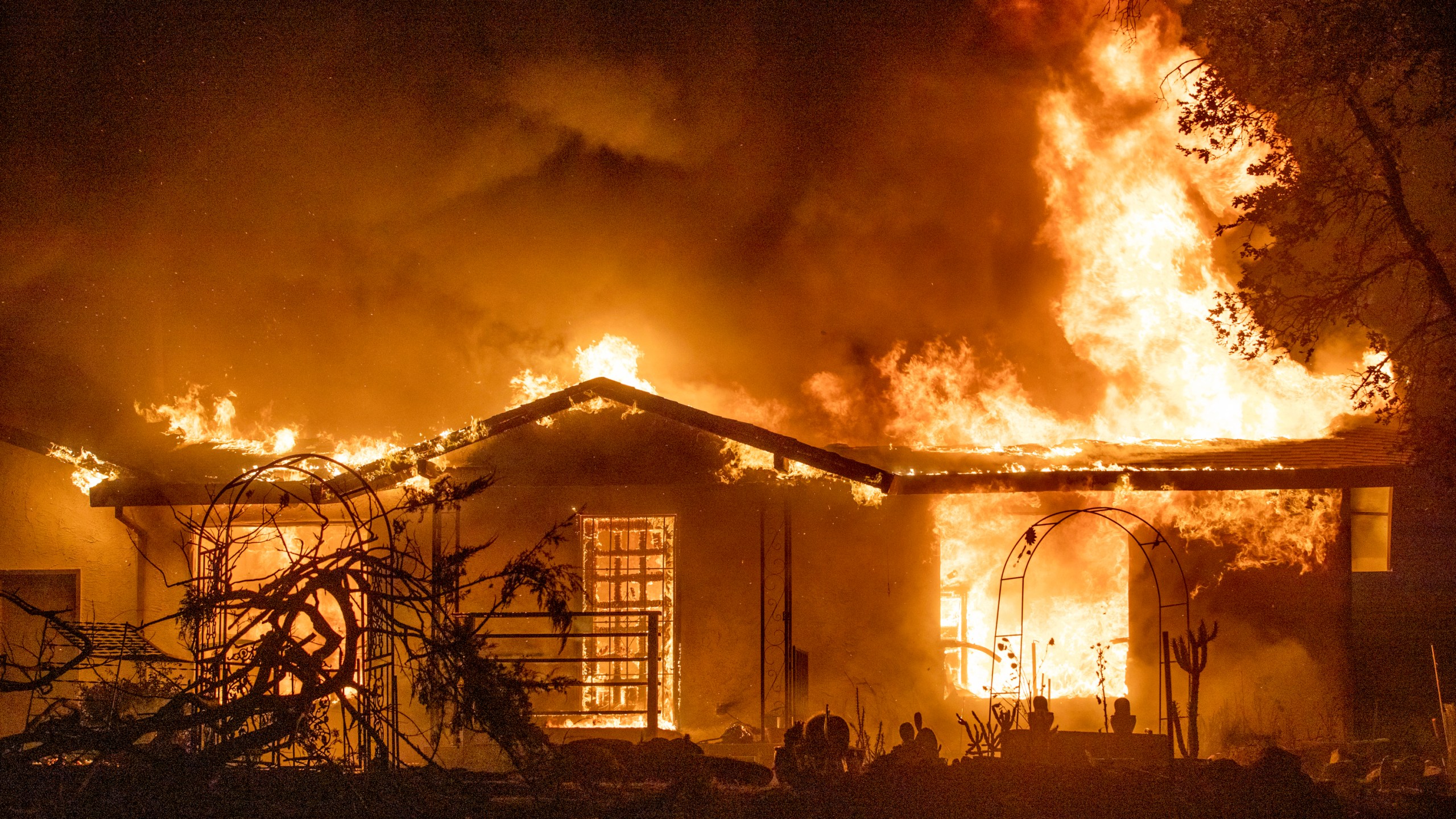 In this Sept. 27, 2020, file photo, a house burns on Platina Road at the Zogg Fire near Ono, Calif. (AP Photo/Ethan Swope, File)