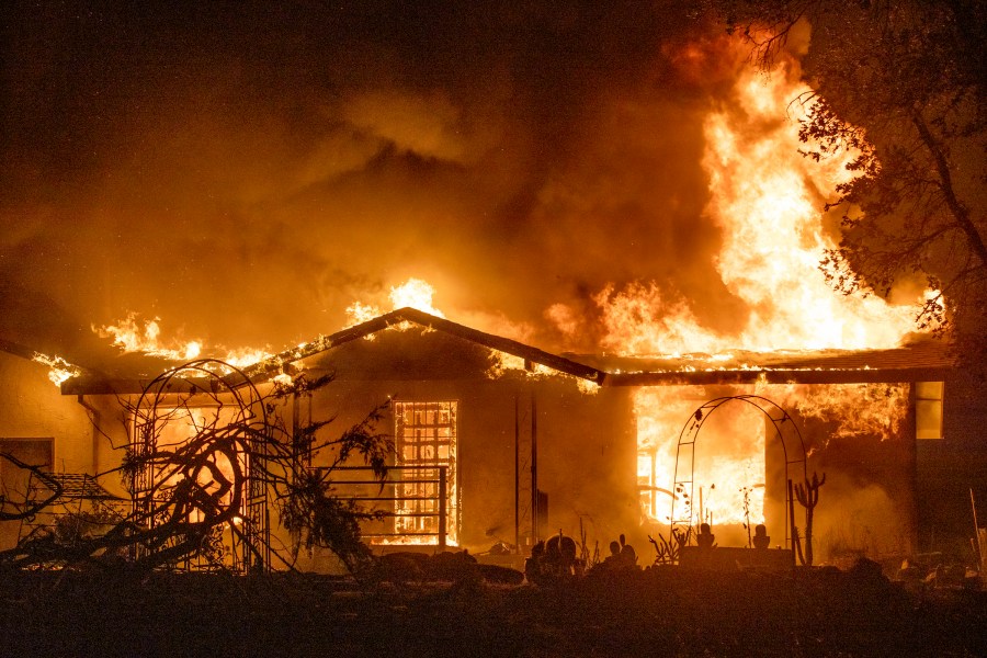 In this Sept. 27, 2020, file photo, a house burns on Platina Road at the Zogg Fire near Ono, Calif. (AP Photo/Ethan Swope, File)