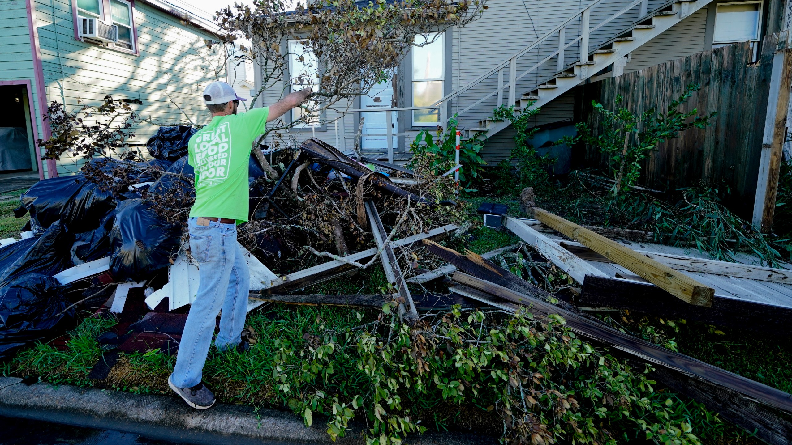 Caleb Cormier moves debris after Hurricane Delta moved through, Saturday, Oct. 10, 2020, in Lake Charles, La. Delta hit as a Category 2 hurricane with top winds of 100 mph (155 kph) before rapidly weakening over land. (AP Photo/Gerald Herbert)