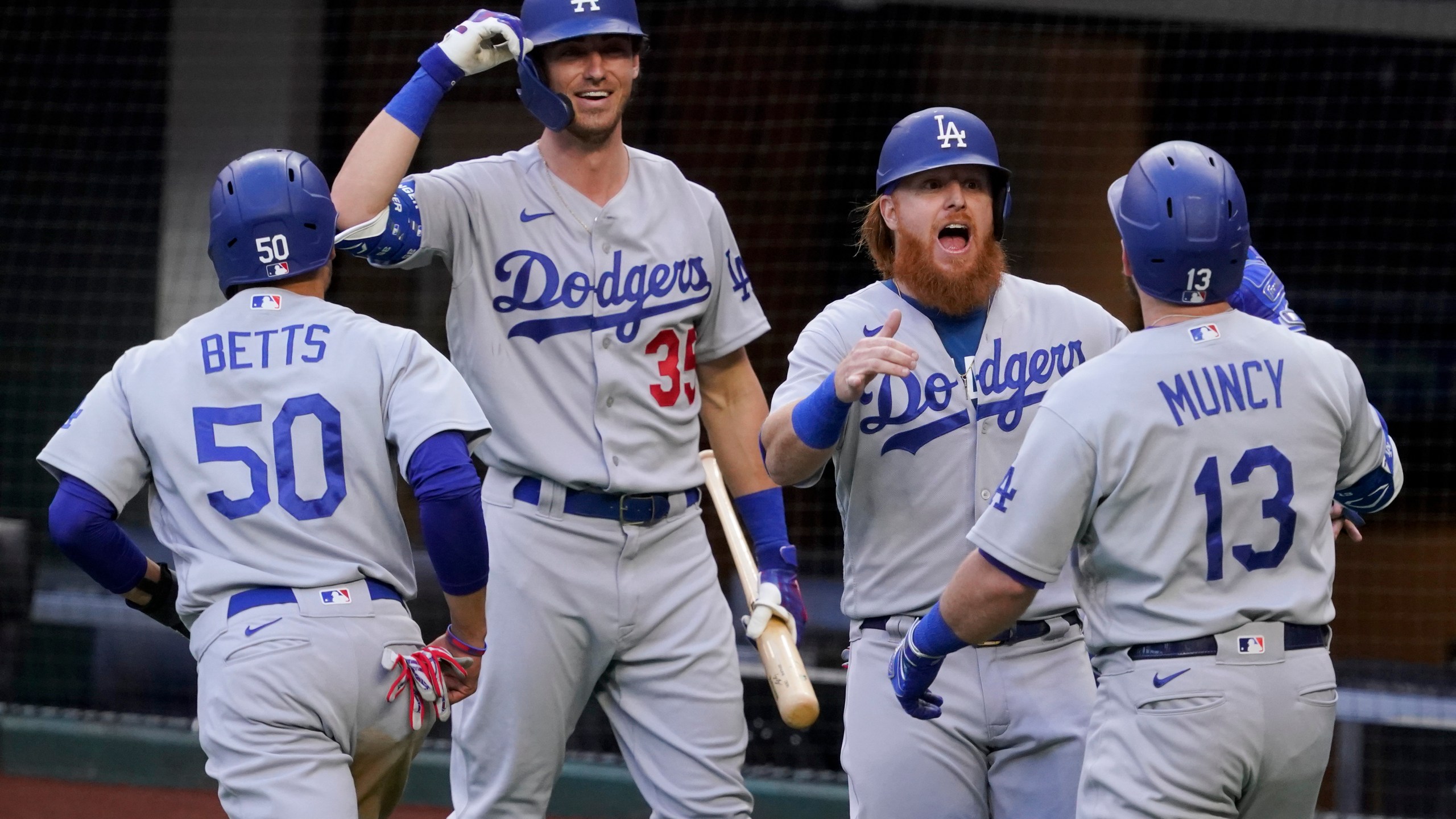 Los Angeles Dodgers' Max Muncy (13) celebrates his grand slam home run during the first inning in Game 3 of a baseball National League Championship Series against the Atlanta Braves on Oct. 14, 2020, in Arlington, Texas. (AP Photo/Tony Gutierrez)