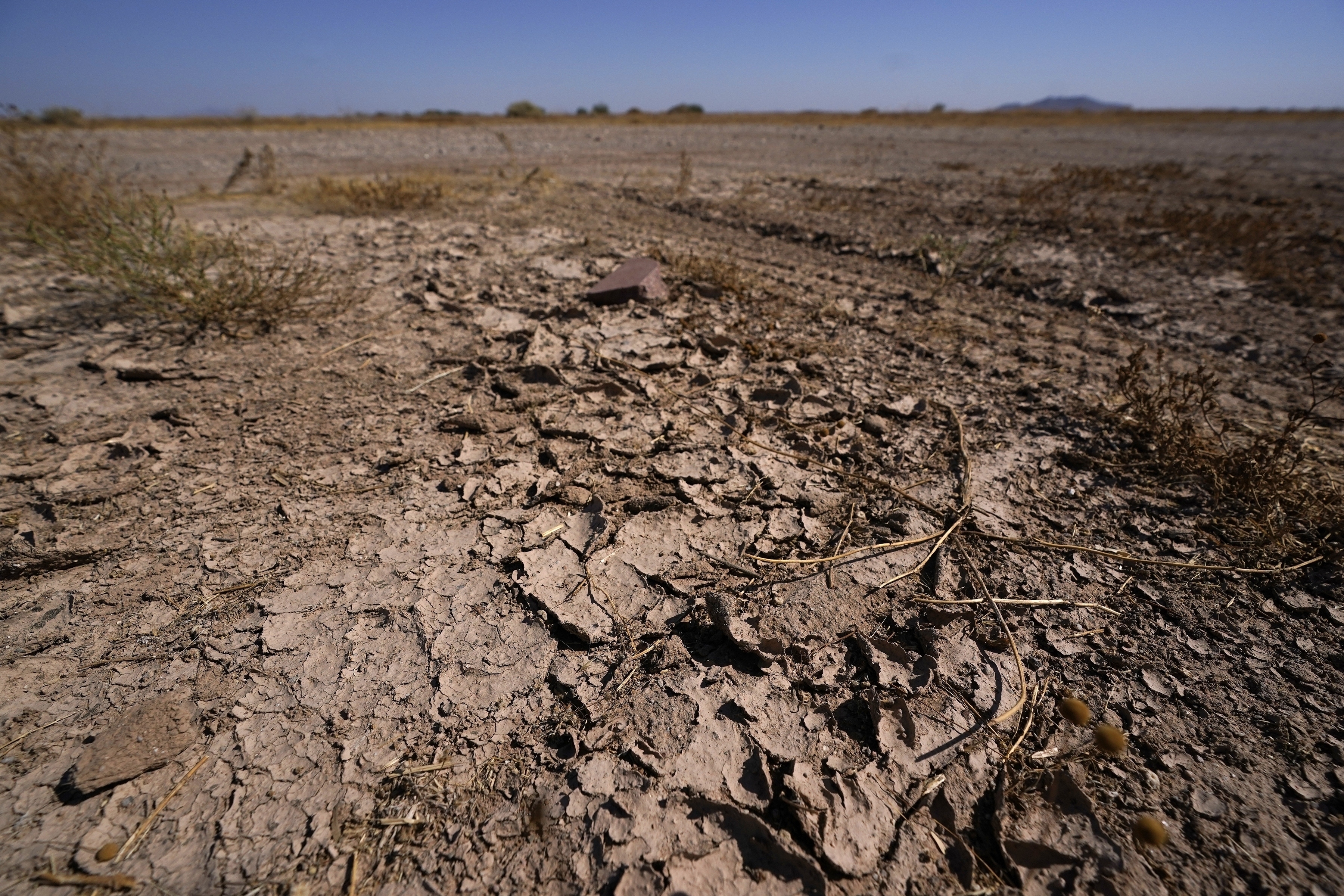 In this Wednesday, Sept. 30, 2020 file photo, dry desert soil cracks due to the lack of monsoon rainfall in Maricopa, Ariz. In a report released on Thursday, Oct. 15, 2020, National Oceanic and Atmospheric Administration forecasters see a dry winter for all of the south from coast-to-coast and say that could worsen an already bad drought. (AP Photo/Ross D. Franklin)