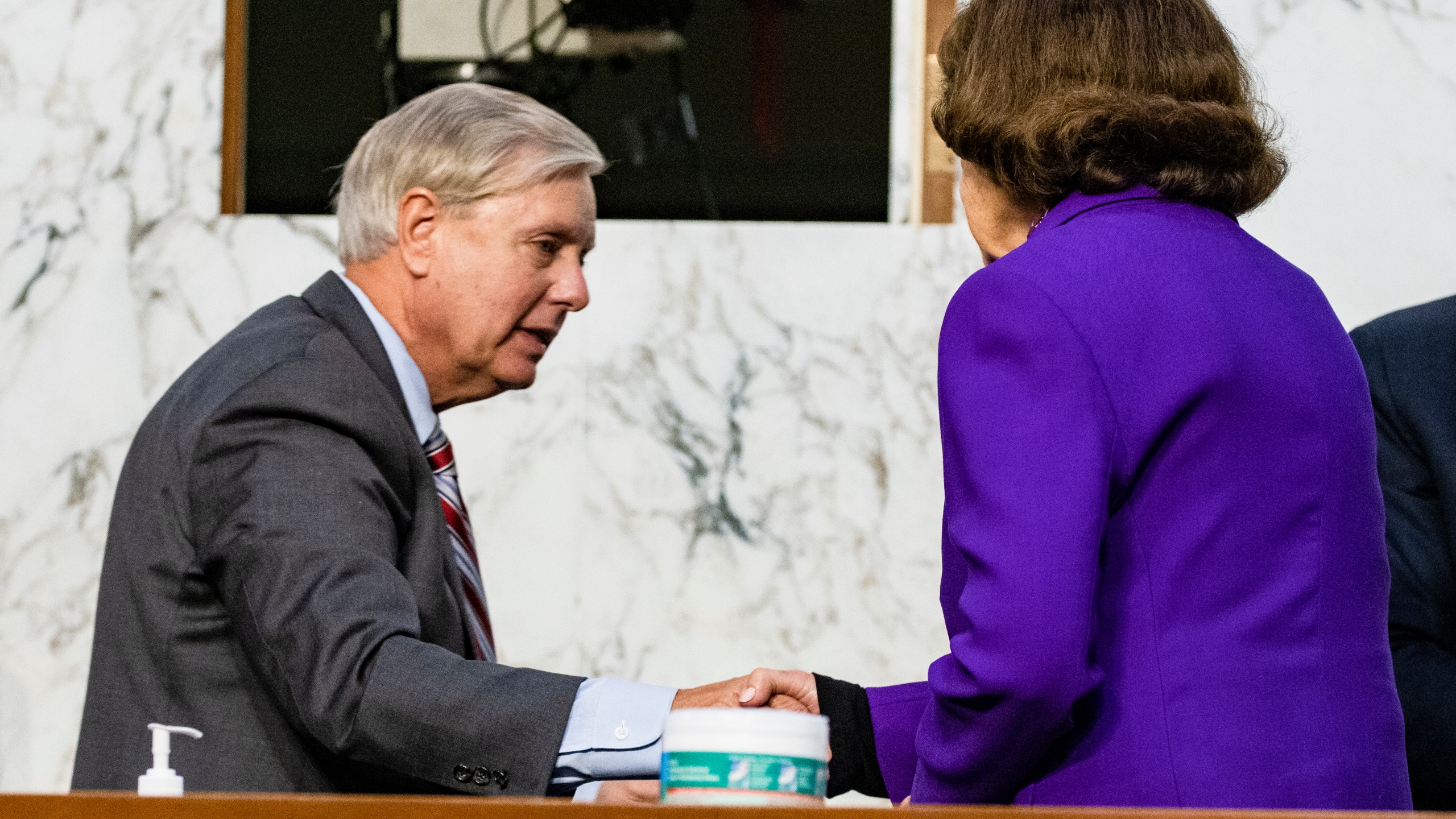 Sen. Lindsey Graham, R-S.C., shakes hands with Sen. Dianne Feinstein, D-Calif., at the close of the confirmation hearing for Supreme Court nominee Amy Coney Barrett, before the Senate Judiciary Committee, Thursday, Oct. 15, 2020, on Capitol Hill in Washington. (Samuel Corum/Pool via AP)