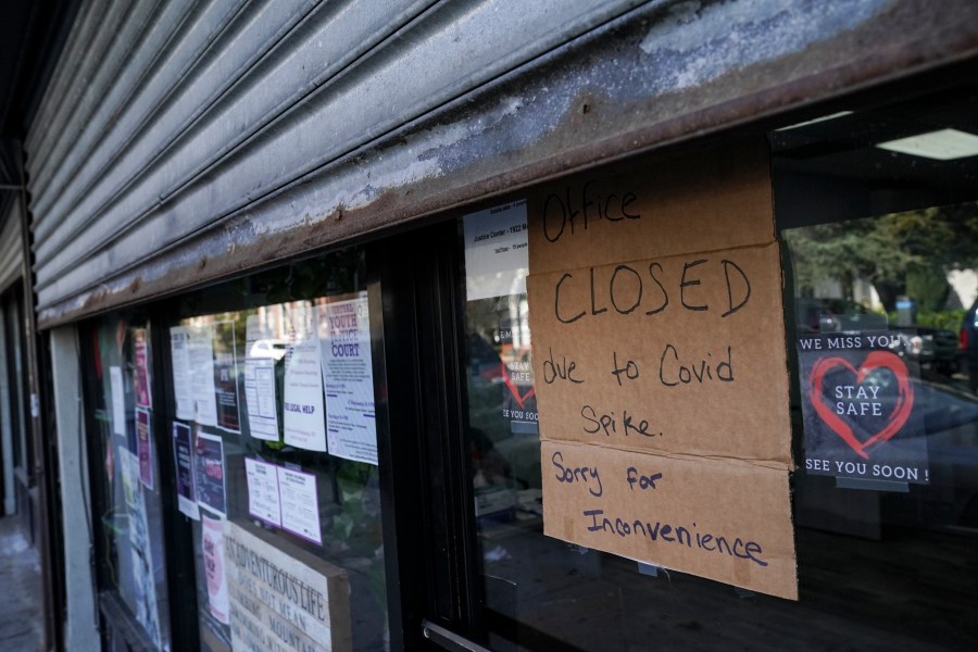 A storefront displays a closed sign as it remains shuttered due to a COVID-19 area infection rate increase, Thursday, Oct. 15, 2020, in the Far Rockaway neighborhood of the borough of Queens in New York. (AP Photo/John Minchillo)