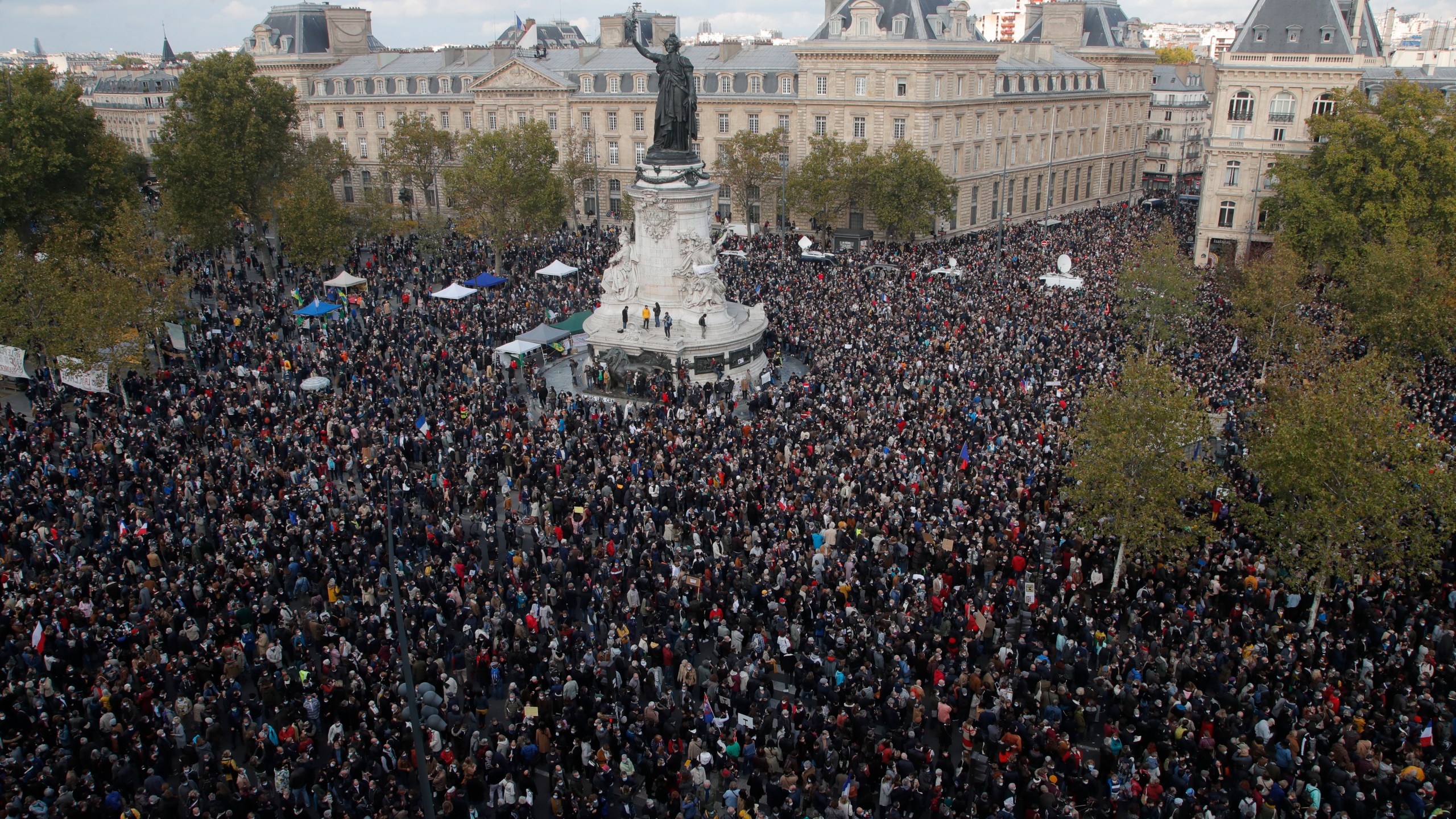 Hundreds of people gather on Republique square during a demonstration Sunday Oct. 18, 2020 in Paris. Demonstrations around France have been called in support of freedom of speech and to pay tribute to a French history teacher who was beheaded near Paris after discussing caricatures of Islam's Prophet Muhammad with his class. Samuel Paty was beheaded on Friday by a 18-year-old Moscow-born Chechen refugee who was shot dead by police. (AP Photo/Michel Euler)