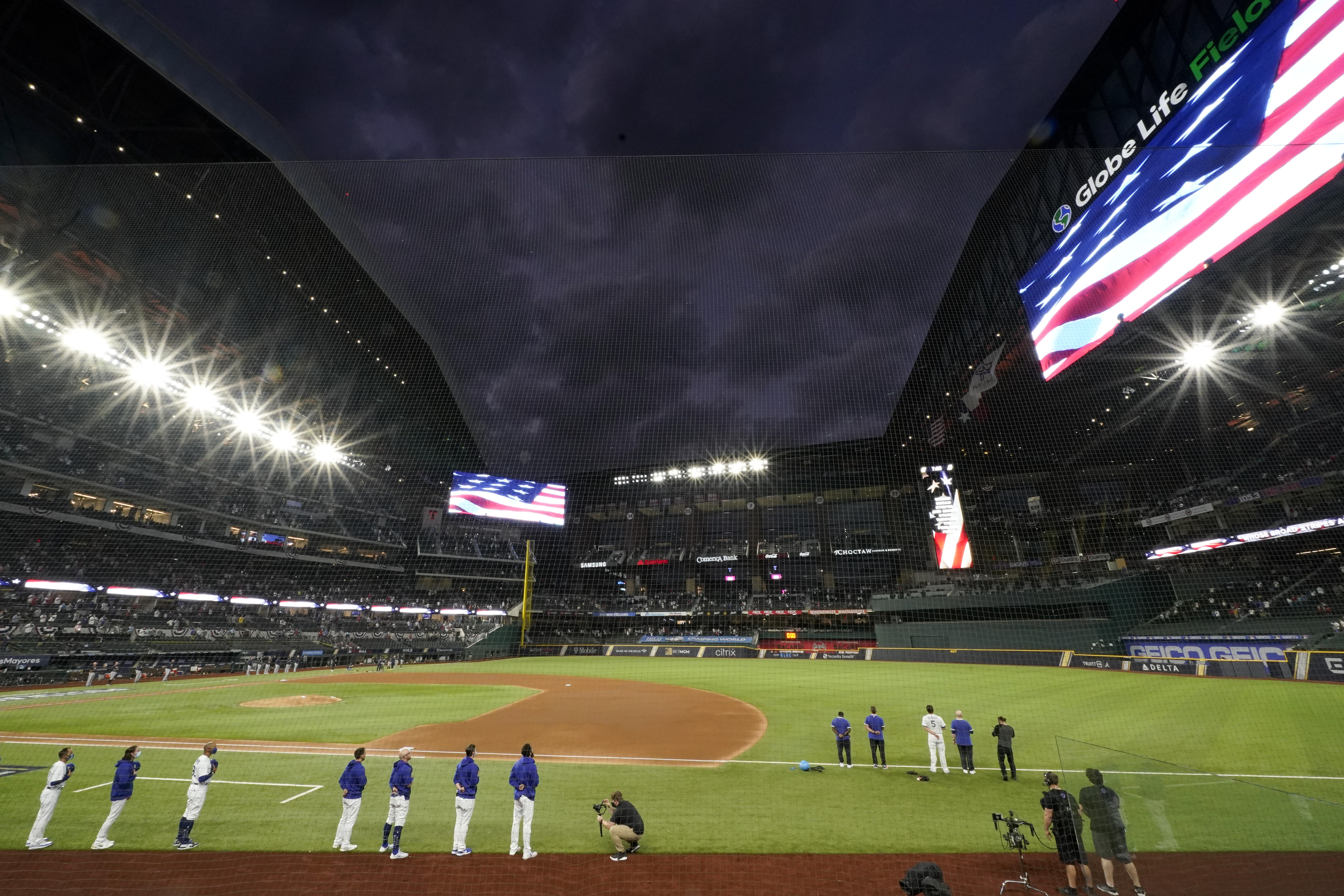 Members of the Los Angeles Dodgers stand during the national anthem before Game 7 of a baseball National League Championship Series Sunday, Oct. 18, 2020, in Arlington, Texas. (AP Photo/Eric Gay)