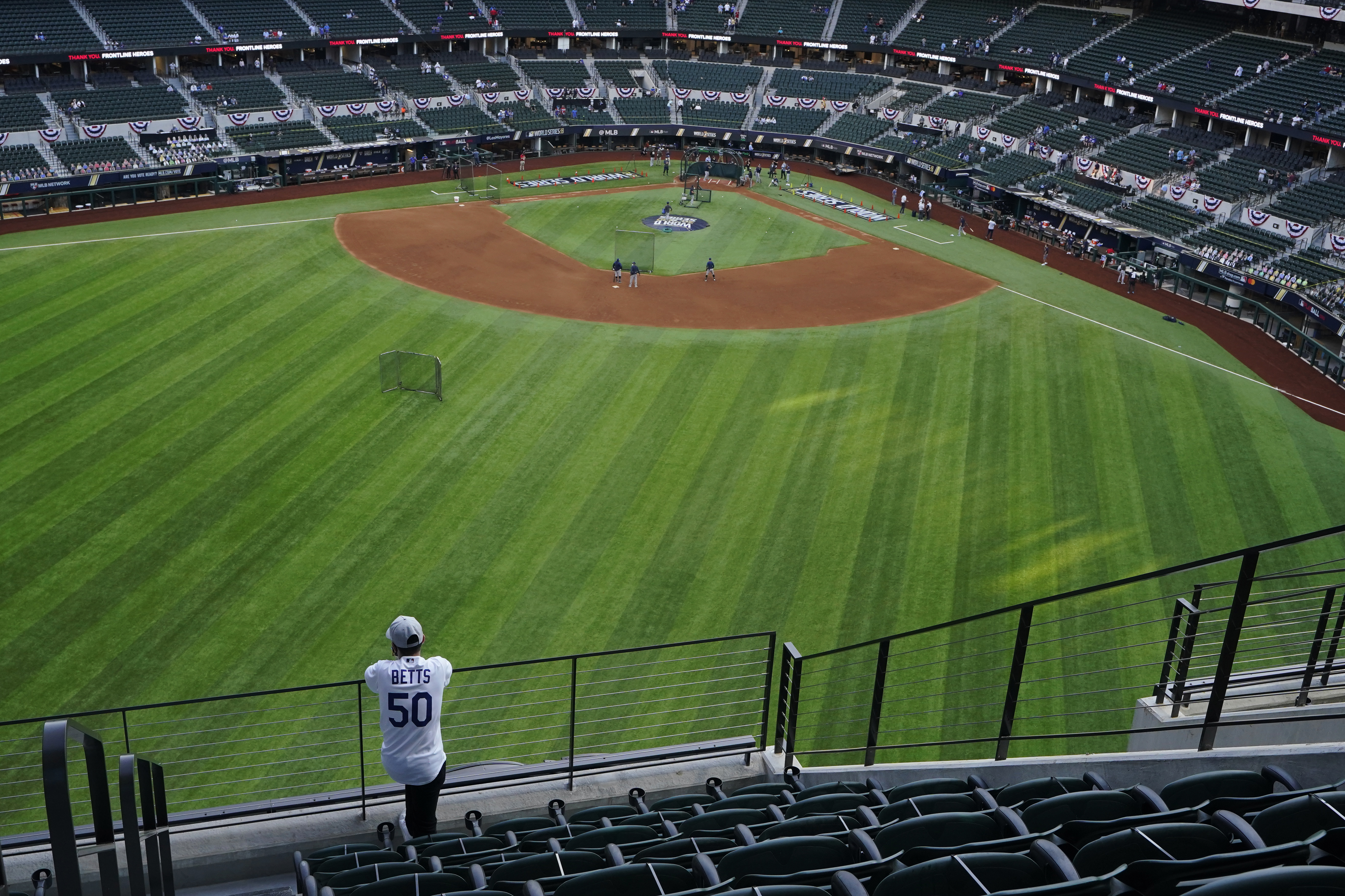 A fan watches batting practice from center field before Game 1 of the baseball World Series between the Los Angeles Dodgers and the Tampa Bay Rays on Oct. 20, 2020, in Arlington, Texas.(AP Photo/Sue Ogrocki)