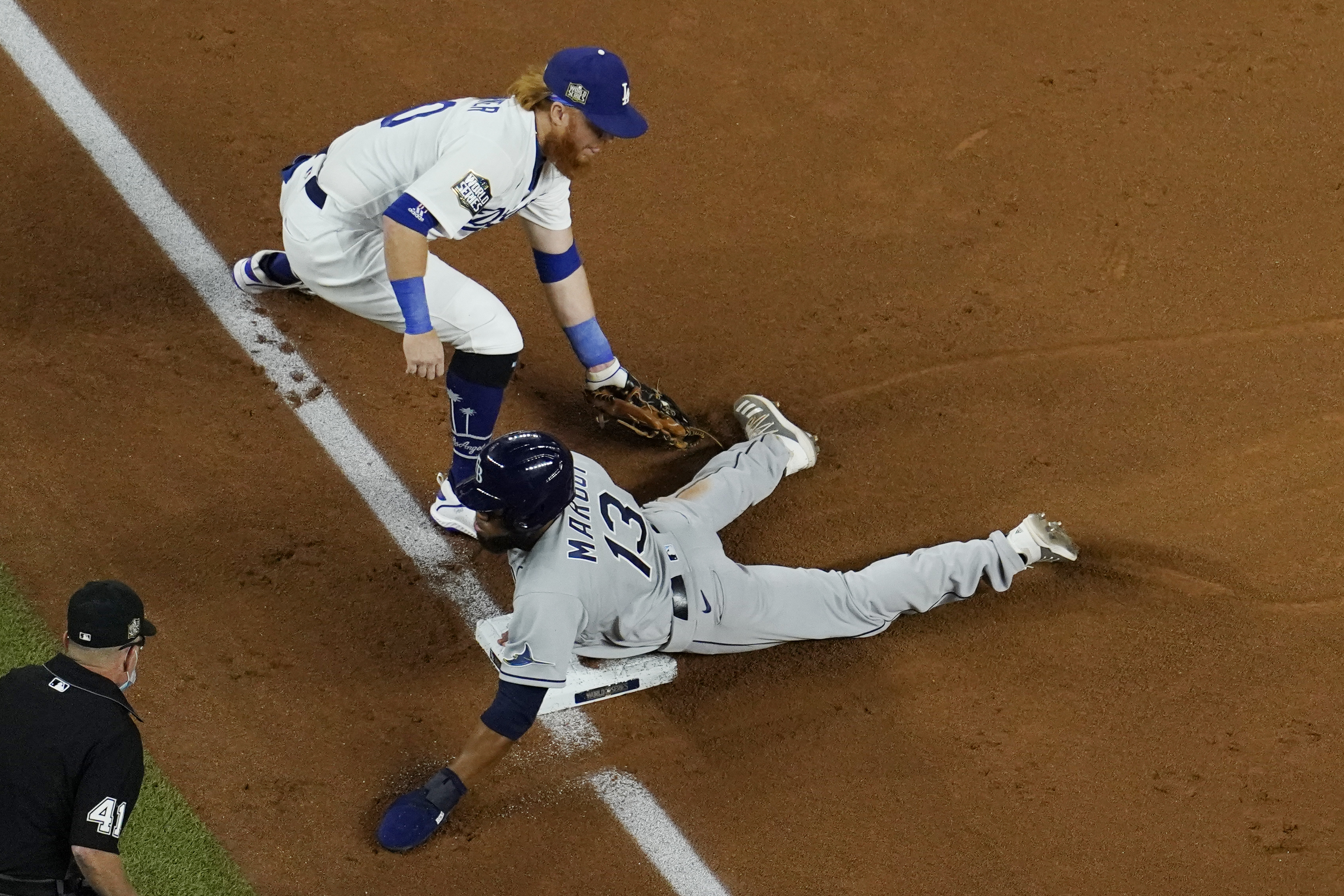 Tampa Bay Rays' Manuel Margot is safe at third past Los Angeles Dodgers third baseman Justin Turner on a ball hit by Joey Wendle during Game 2 of the World Series on Oct. 21, 2020, in Arlington, Texas. (David J. Phillip / Associated Press)