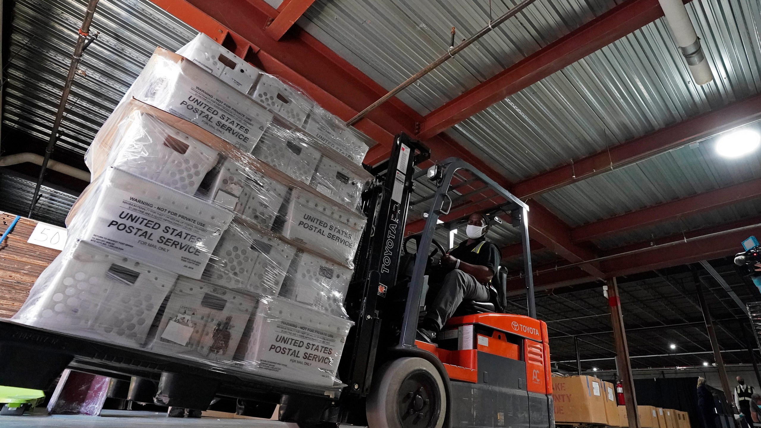 In this Sept. 3, 2020, file photo, a forklift operator loads absentee ballots for mailing at the Wake County Board of Elections as preparations for the upcoming election are ongoing in Raleigh, N.C. U.S. Postal Service records show delivery delays have persisted across the country as millions of Americans began voting by mail, raising the possibility of ballots being rejected because they arrive too late. Postal data covering the beginning of October show nearly all of the agency's delivery regions missing agency targets of having more than having more than 95% of first-class mail arrive within five days. (AP Photo/Gerry Broome, File)