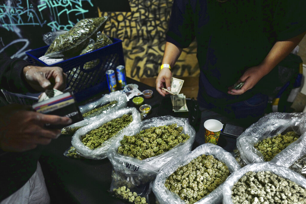 In this April 15, 2019, file photo, a vendor makes change for a marijuana customer at a cannabis marketplace in Los Angeles. (AP Photo/Richard Vogel, File)