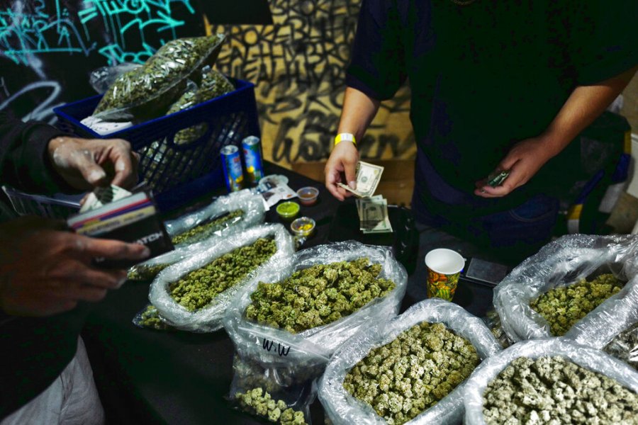 In this April 15, 2019, file photo, a vendor makes change for a marijuana customer at a cannabis marketplace in Los Angeles. (AP Photo/Richard Vogel, File)