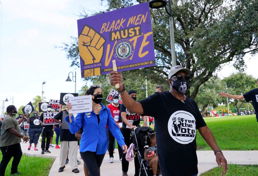 Supporters of restoring Florida felons' voting rights march to an early voting precinct, Saturday, Oct. 24, 2020, in Fort Lauderdale, Fla. (AP Photo/Marta Lavandier)