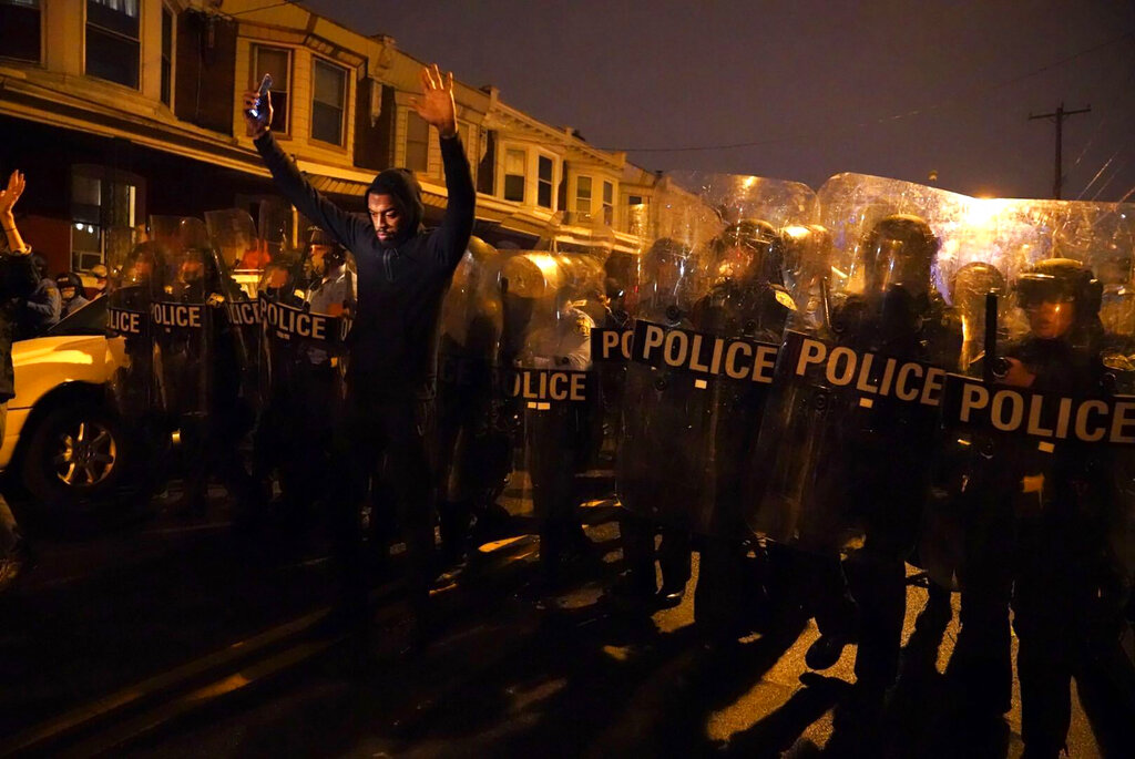 Sharif Proctor lifts his hands up in front of the police line during a protest in response to the police shooting of Walter Wallace Jr., Monday, Oct. 26, 2020, in Philadelphia. (Jessica Griffin/The Philadelphia Inquirer via AP)