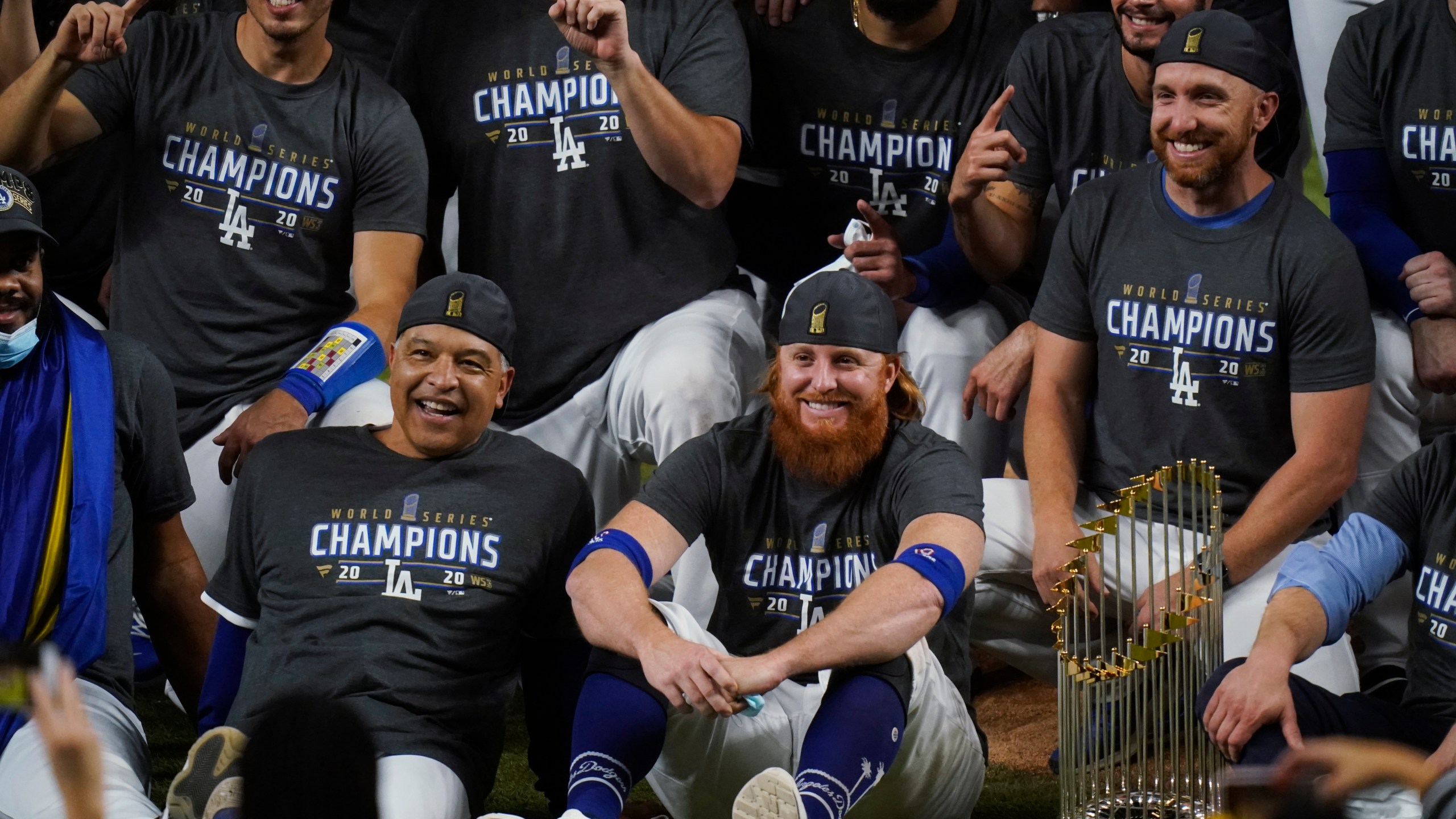 Los Angeles Dodgers manager Dave Roberts and third baseman Justin Turner pose for a group picture after the Dodgers defeated the Tampa Bay Rays 3-1 in Game 6 to win the baseball World Series, Tuesday, Oct. 27, 2020, in Arlington, Texas. The picture was taken after Turner was pulled from the game due to a positive coronavirus test. (AP Photo/Eric Gay)