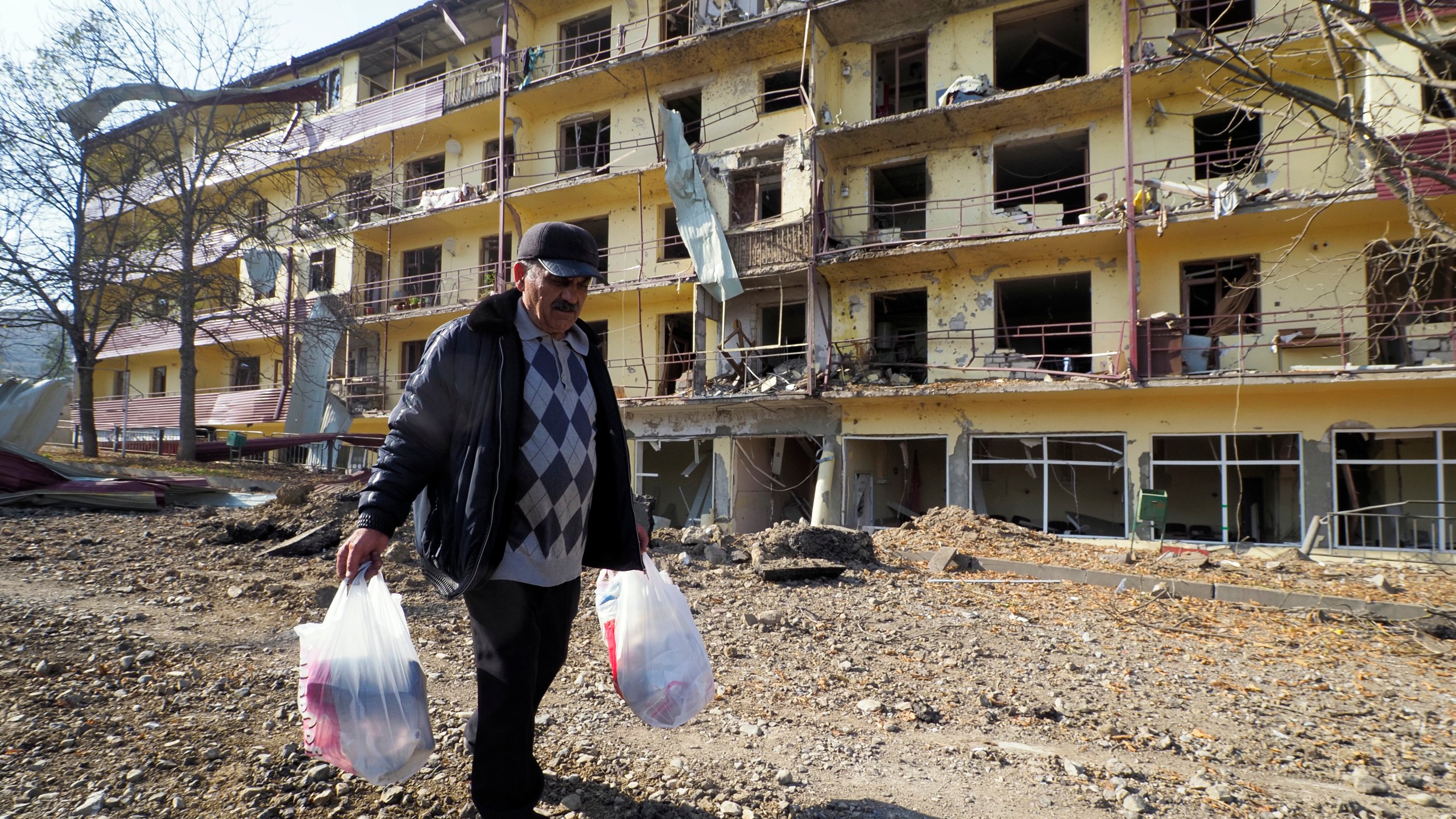 Vovik Zakharian, 72, walks past his apartment building damaged by shelling by Azerbaijan's forces during a military conflict in Shushi, in the separatist region of Nagorno-Karabakh, on Oct. 29, 2020. (Associated Press)