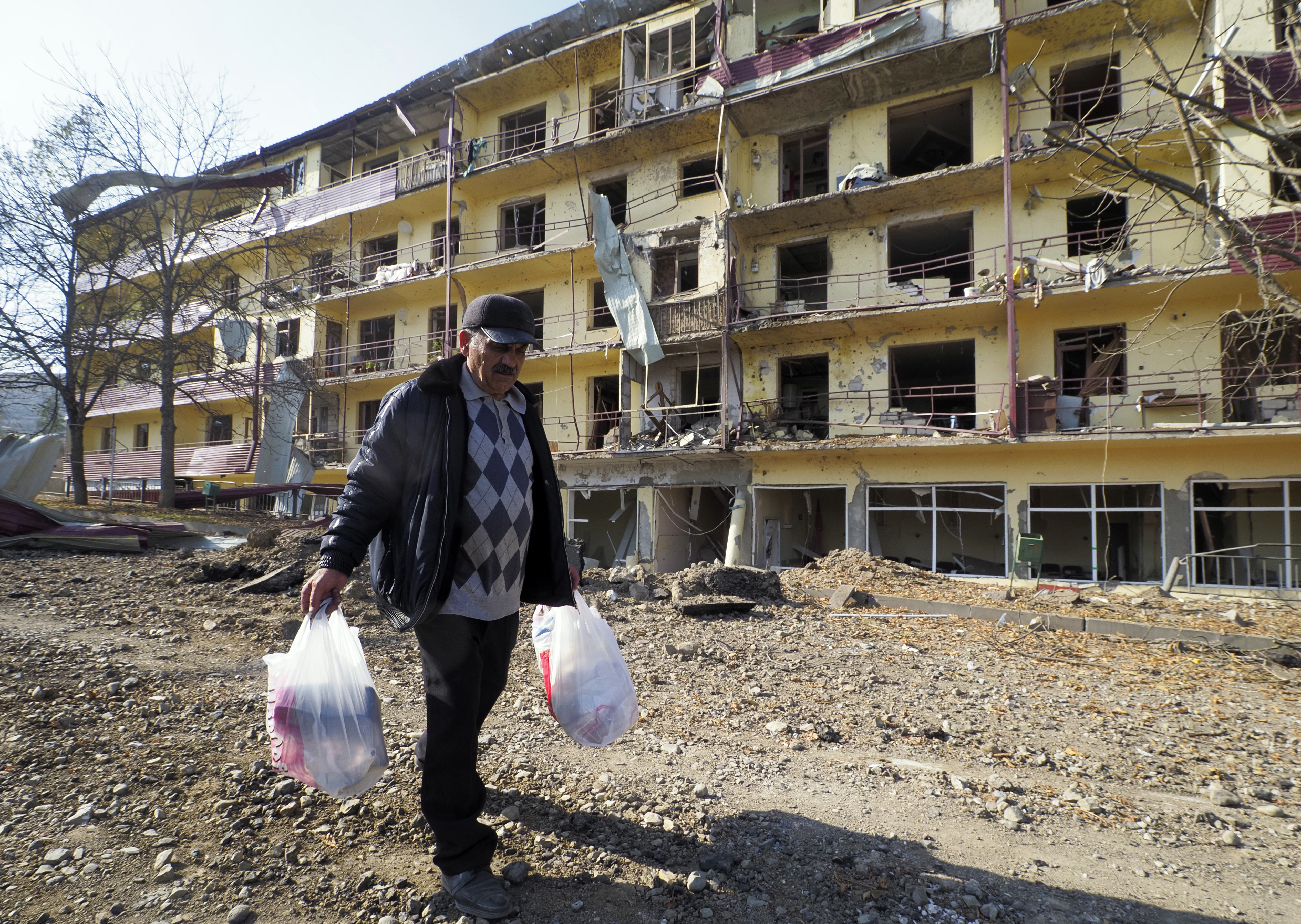 Vovik Zakharian, 72, walks past his apartment building damaged by shelling by Azerbaijan's forces during a military conflict in Shushi, in the separatist region of Nagorno-Karabakh, on Oct. 29, 2020. (Associated Press)