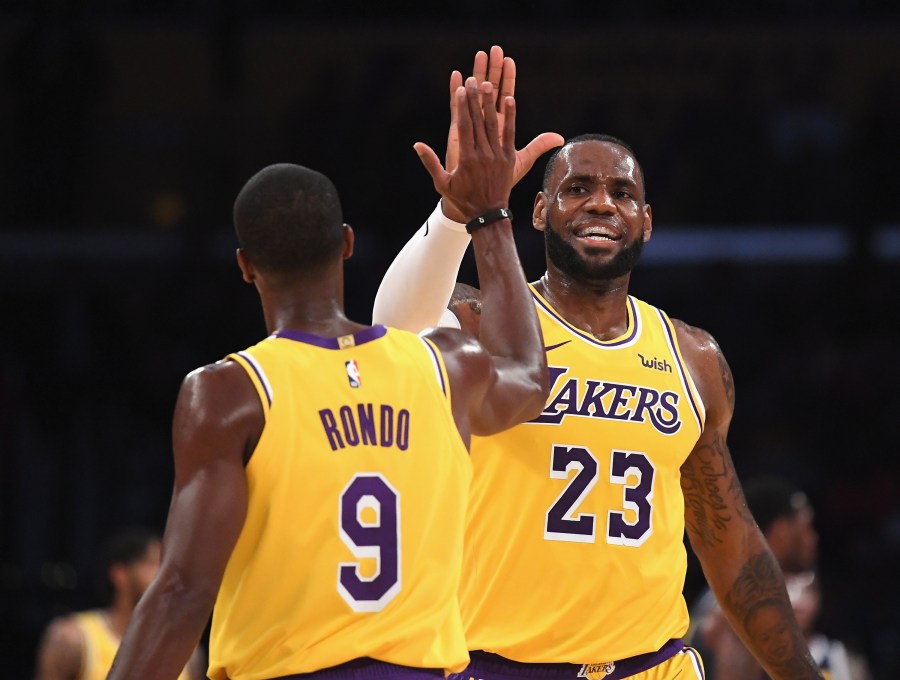 LeBron James of the Los Angeles Lakers high fives Rajon Rondo during a preseason game against the Denver Nuggets at Staples Center on Oct. 2, 2018. (Harry How / Getty Images)