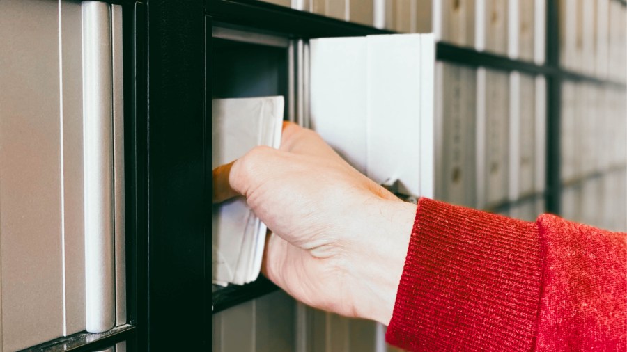 A woman pulls out a stack of letters from a mail box in this undated file photo. (Getty Images)