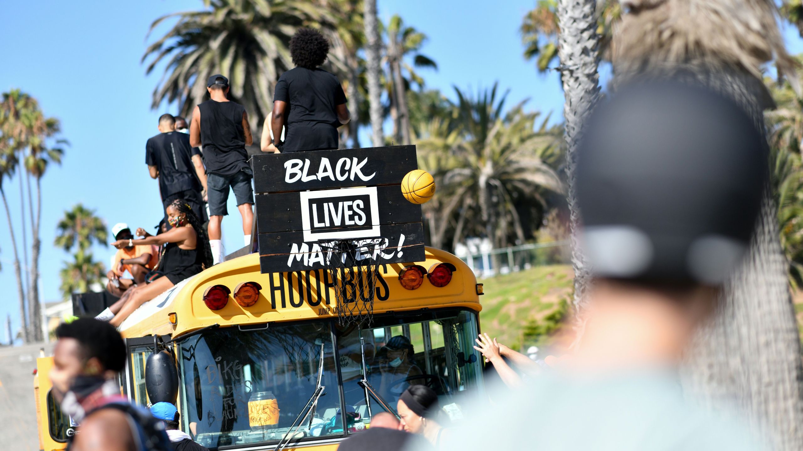 Protesters shoot a basketball at the "hoop bus" after riding their bikes to the beach during the Bike Rides for Black Lives demonstration in support of the Black Lives Matter in Santa Monica, California, on July 12, 2020. (CHRIS DELMAS/AFP via Getty Images)