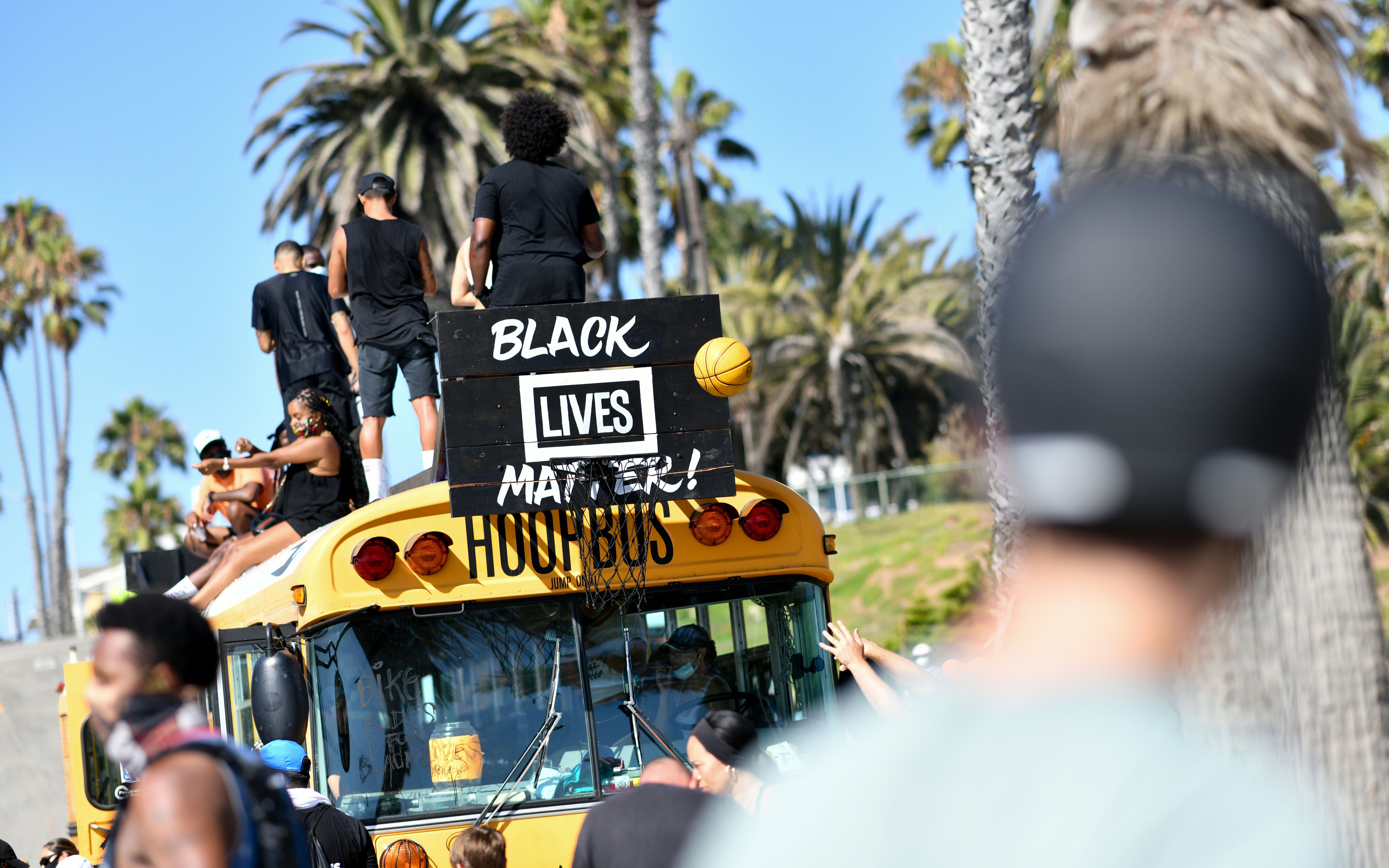 Protesters shoot a basketball at the "hoop bus" after riding their bikes to the beach during the Bike Rides for Black Lives demonstration in support of the Black Lives Matter in Santa Monica, California, on July 12, 2020. (CHRIS DELMAS/AFP via Getty Images)