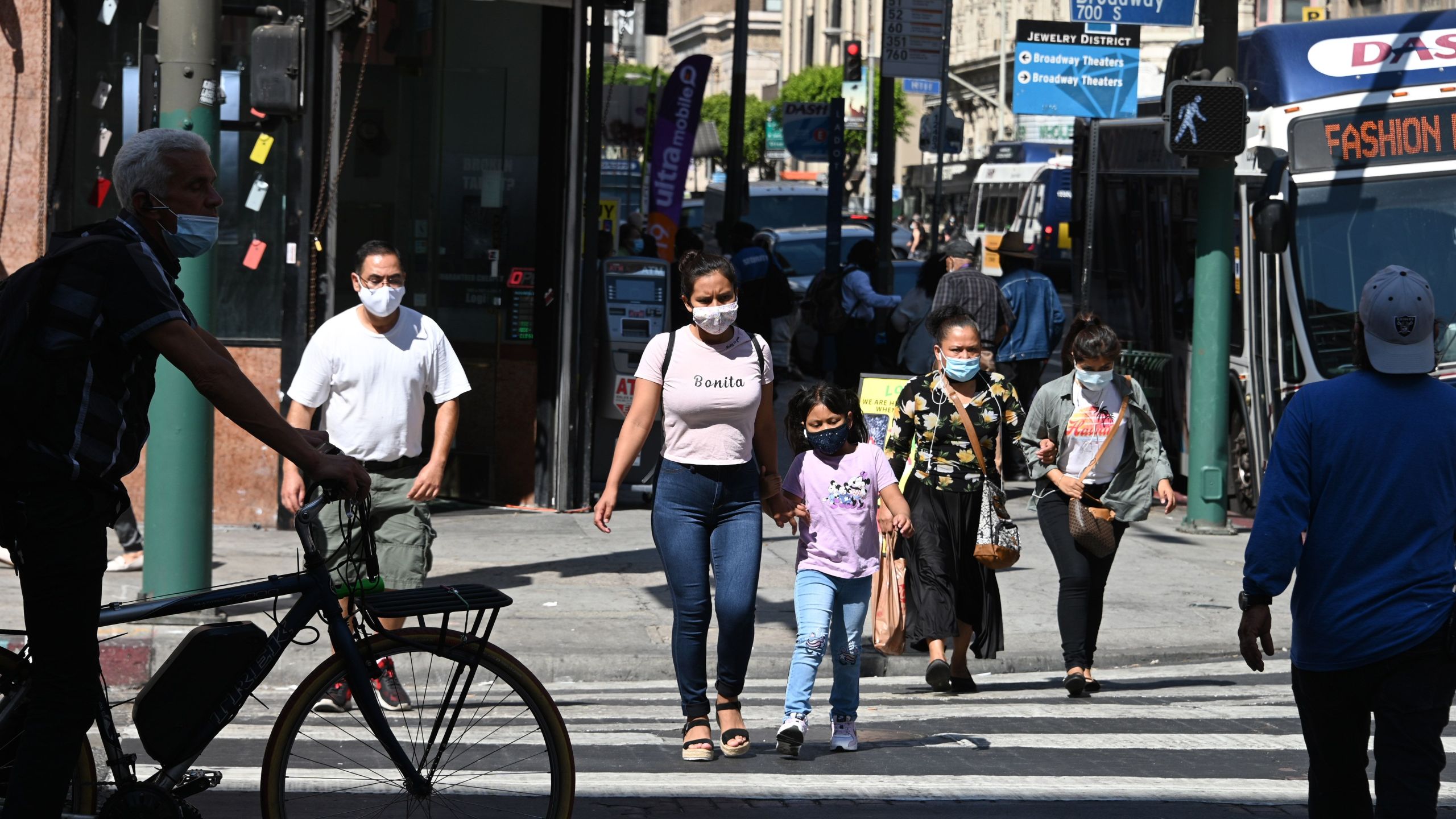 People wearing masks walk on a street in downtown Los Angeles on Oct. 2, 2020 (Photo by Robyn Beck/AFP via Getty Images)