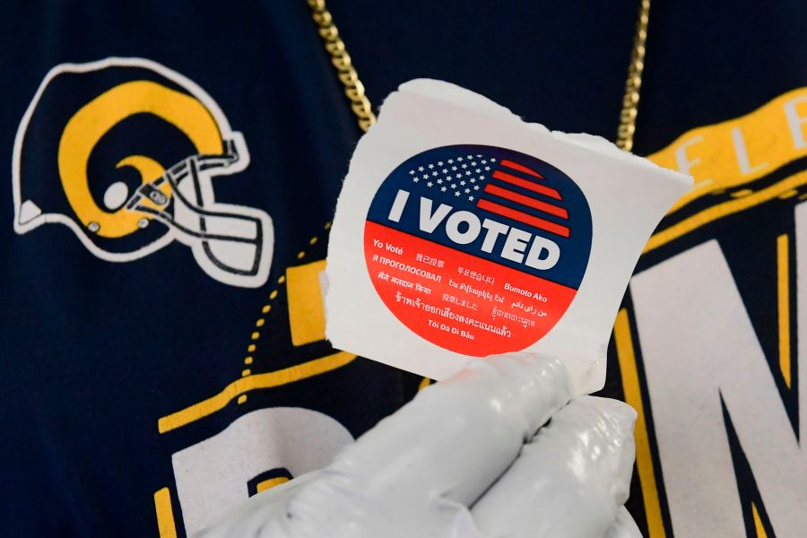 A voter displays his "I voted" sticker after casting a ballot in the 2020 presidential election at the Los Angeles County Registrar’s Office in Norwalk on Oct. 19, 2020.(Frederic J. Brown / AFP / Getty Images)