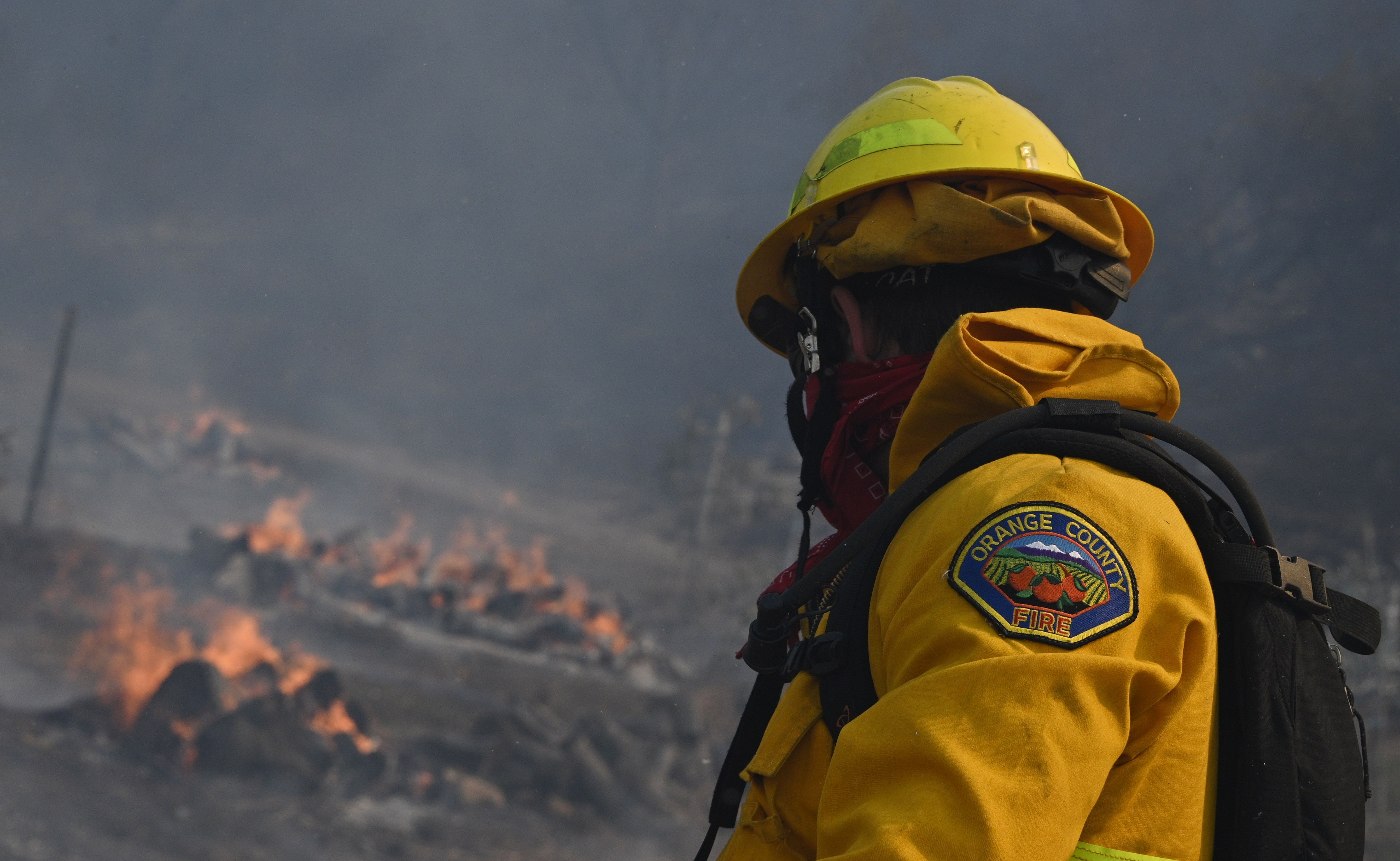 An Orange County firefighter looks for hotspots near a residential area in the Silverado Fire October 26, 2020 in Irvine, California. (ROBYN BECK/AFP via Getty Images)